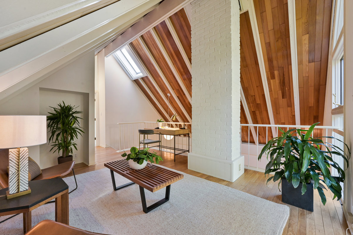 029048 View of the top-floor living area and balcony that's open to the living room below