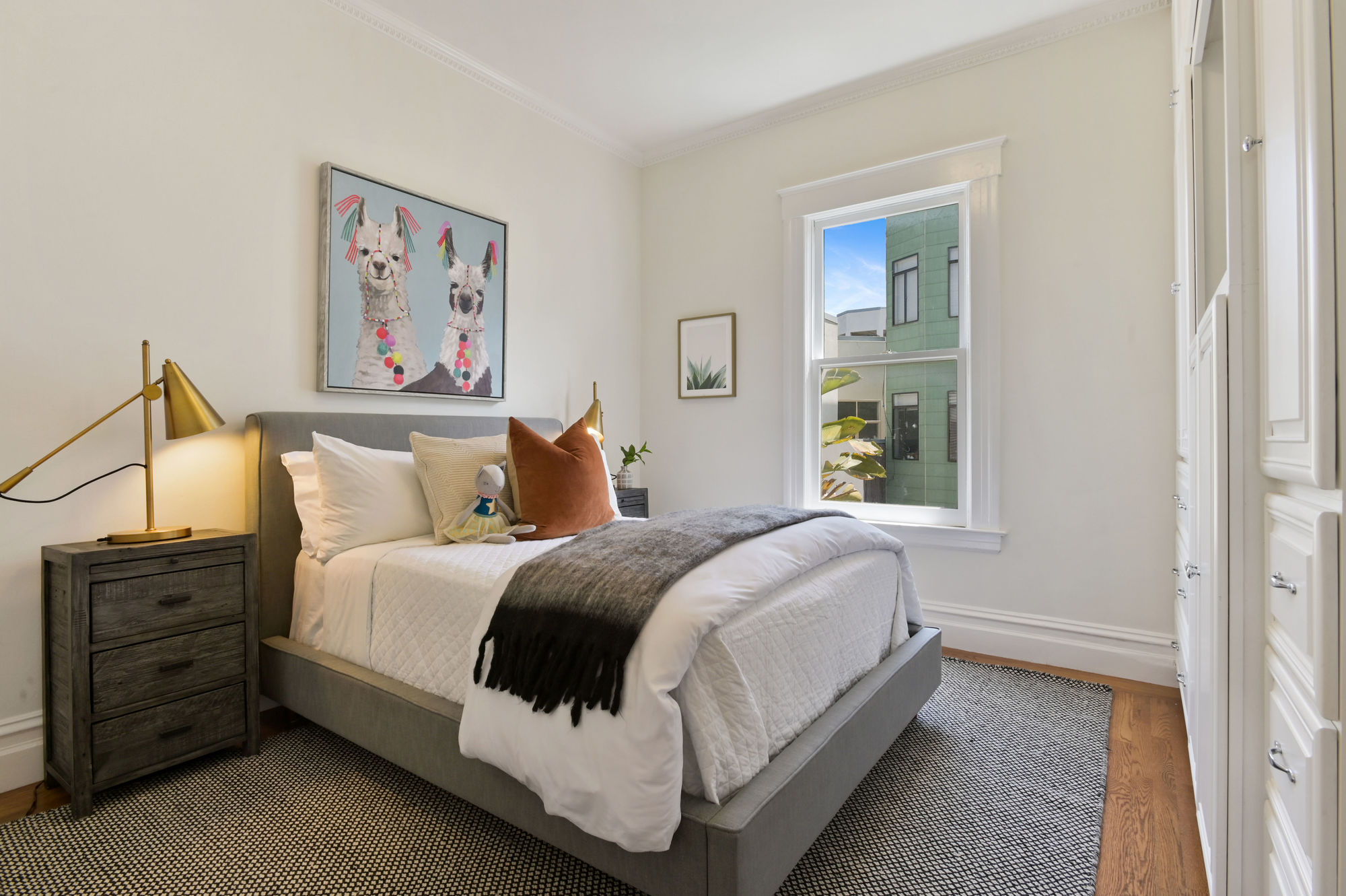 View of another bedroom with one large window and wood floors
