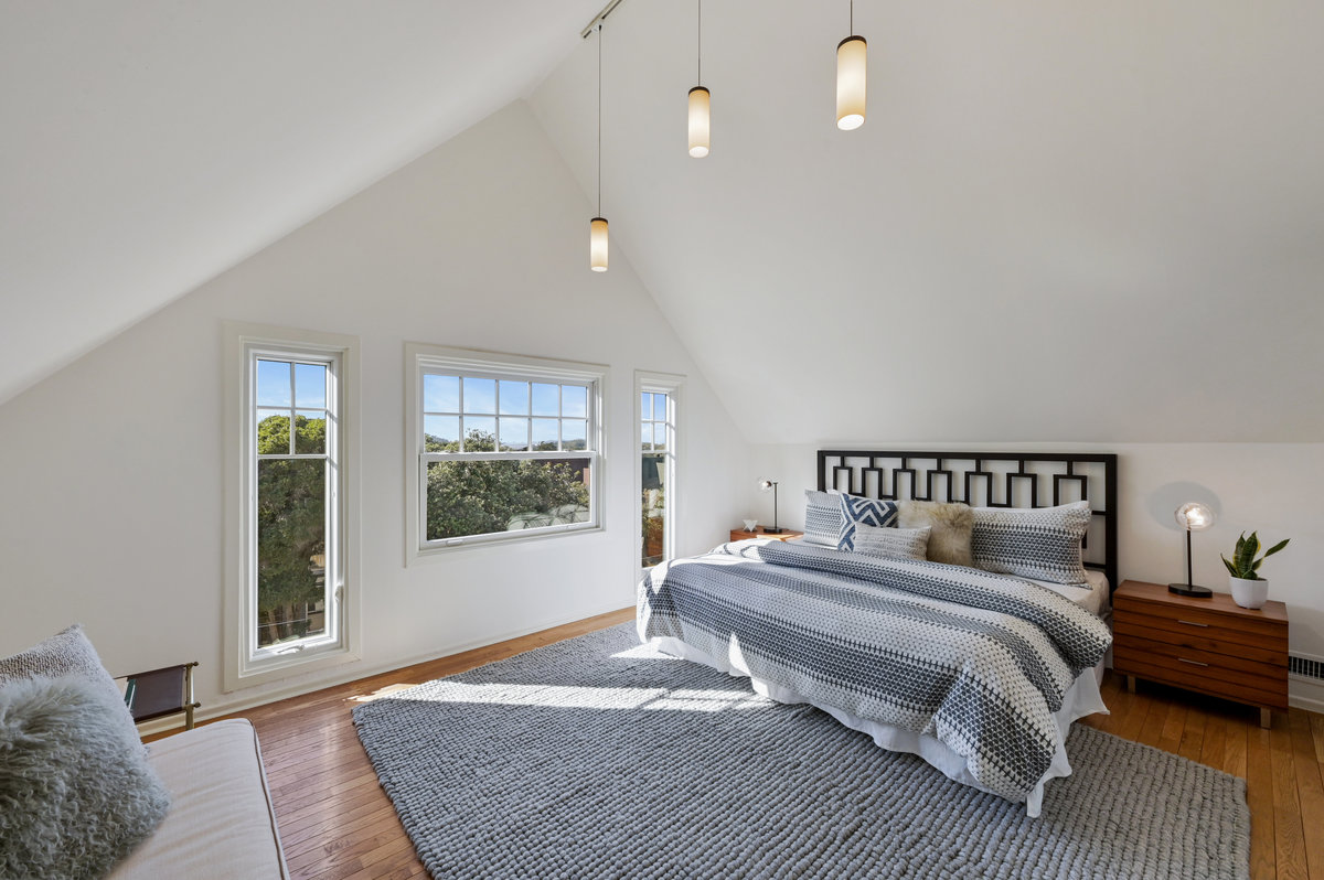 031053 View of the primary bedroom, featuring wood floor and plenty of natural light