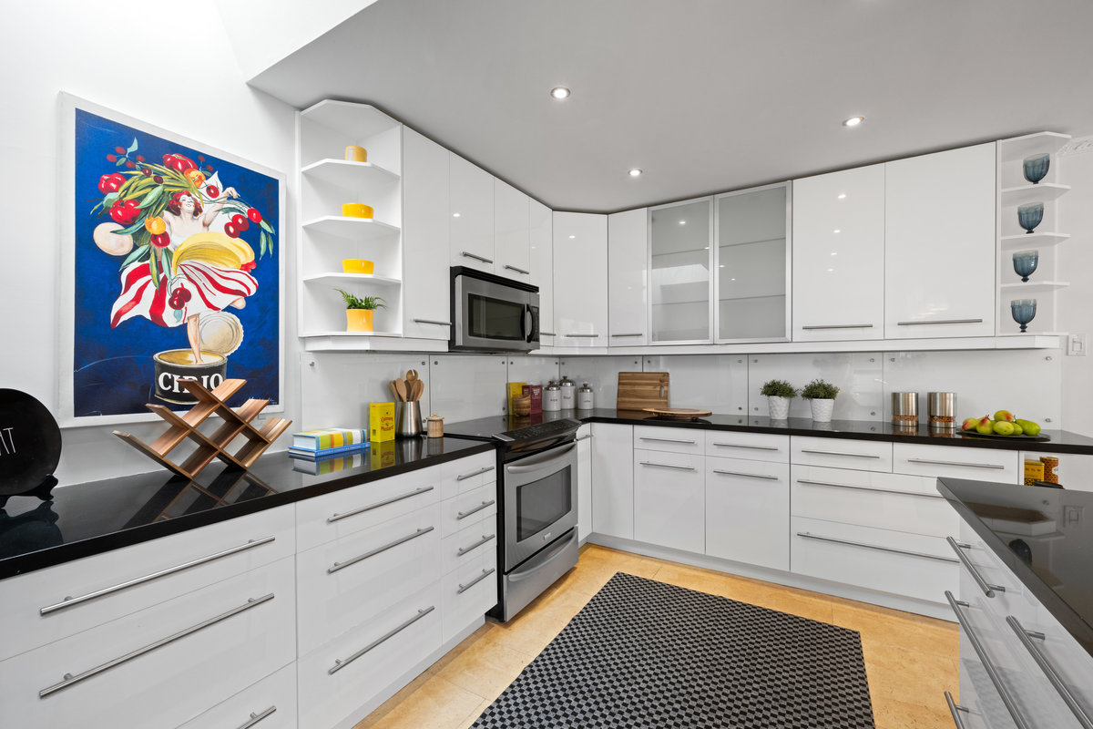 Kitchen has upper open corner shelves  and lots of natural light.