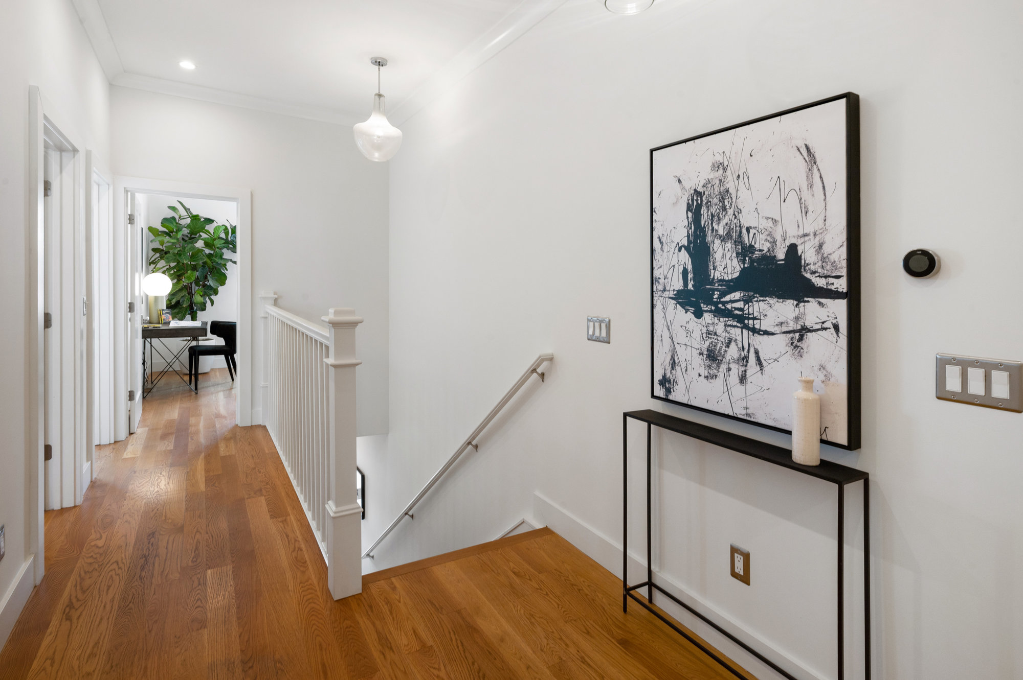 View of the upper hallway with wood floors