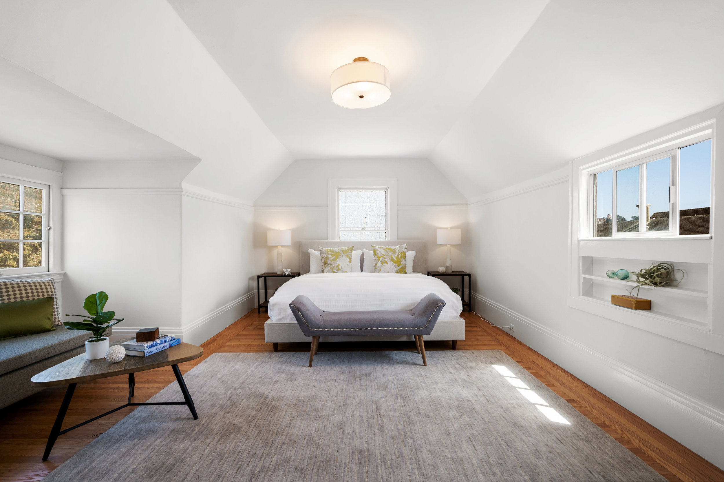 Primary bedroom with coved ceiling and windows on three sides of the room