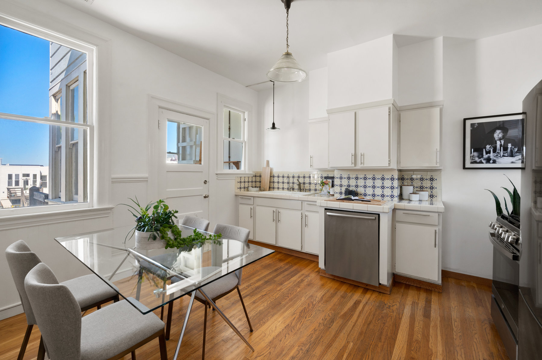 Kitchen has eat in area that fits 4, there are hardwood floors and there is a stainless dishwasher next to skink.