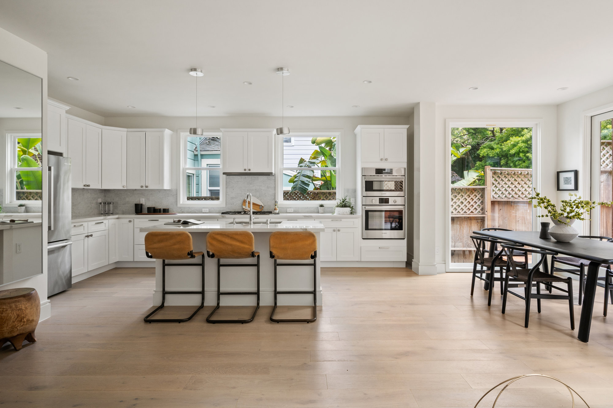 Looking at kitchen.  White stone counter tops with all white cabinets.