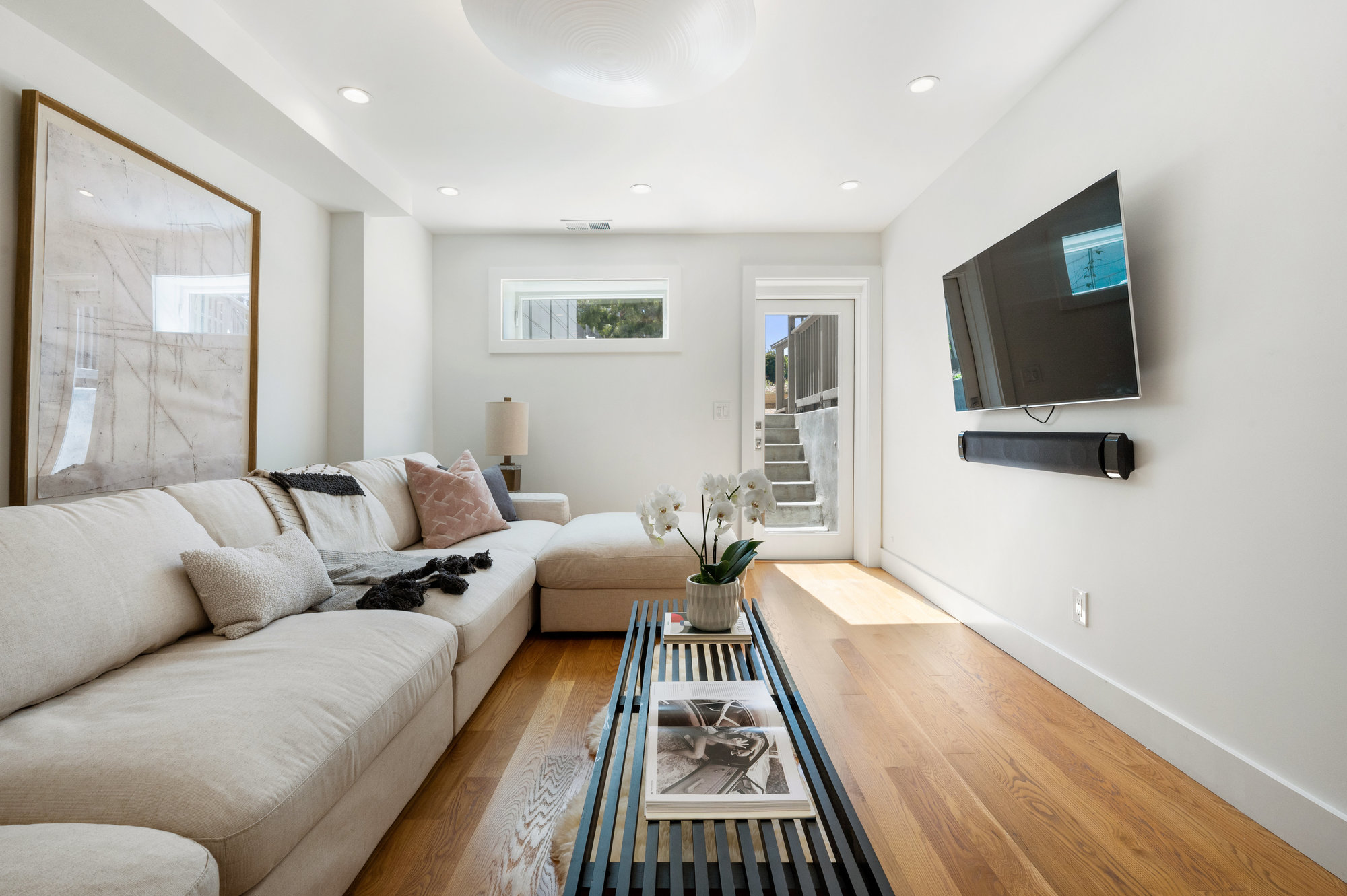 Lower living area with recess lighting, wood floors, and lots of natural light