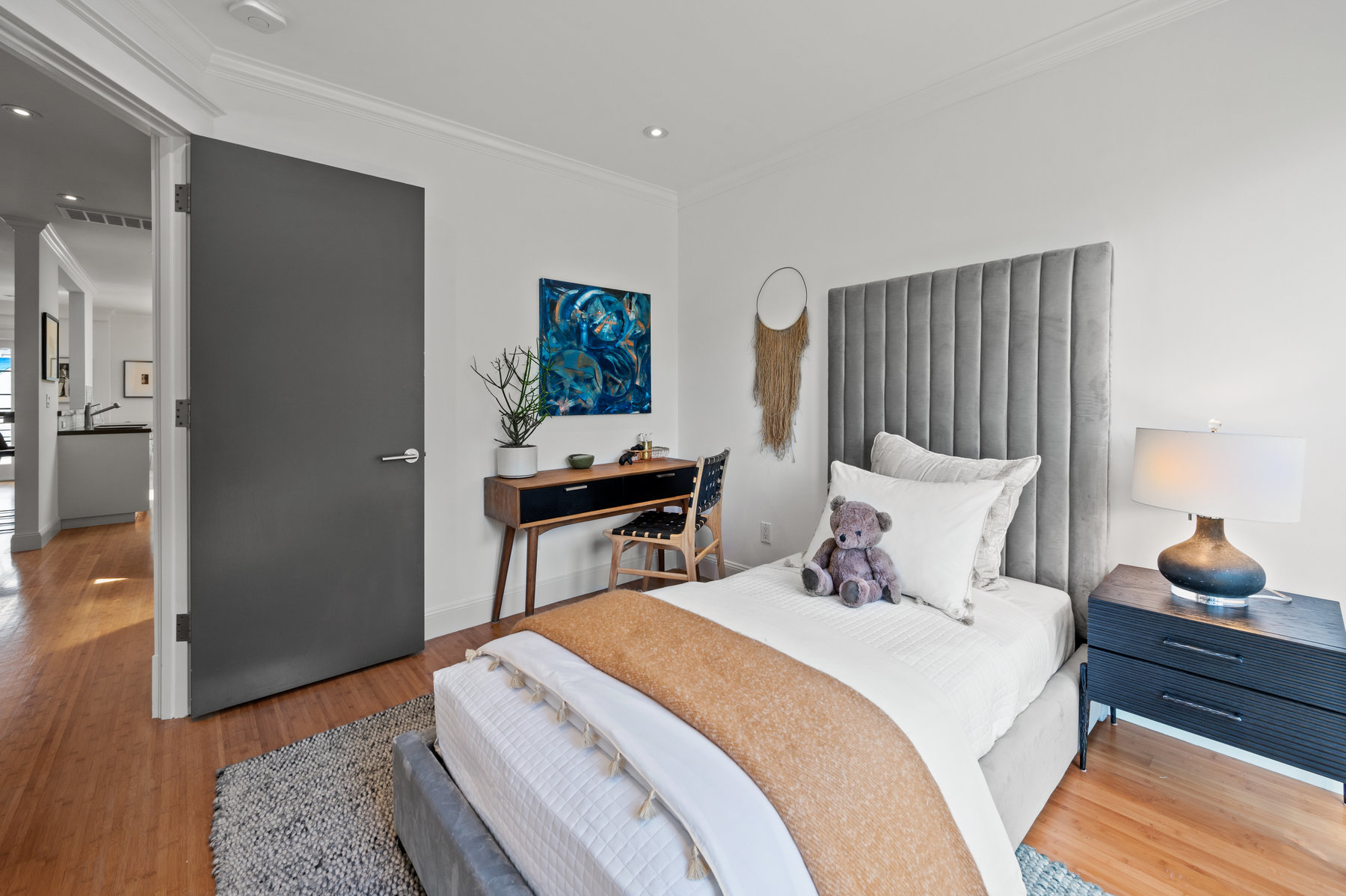 The second bedroom has a twin bed, bedside table and small desk with chair.