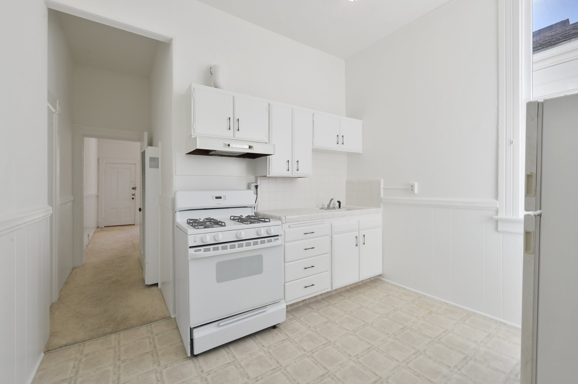 038046 A kitchen with white cabinets and stove