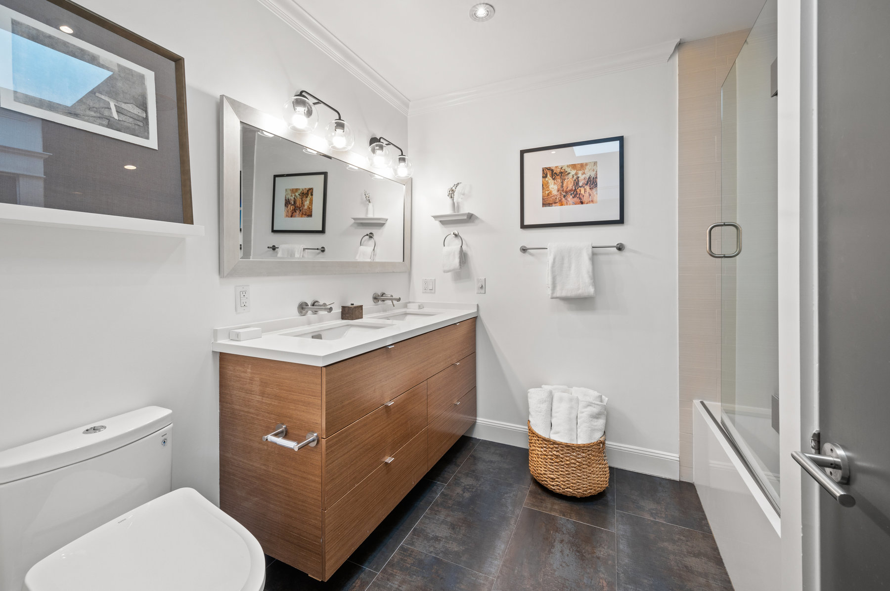 Bathroom has double vanity with white countertops and large tub/shower combo.