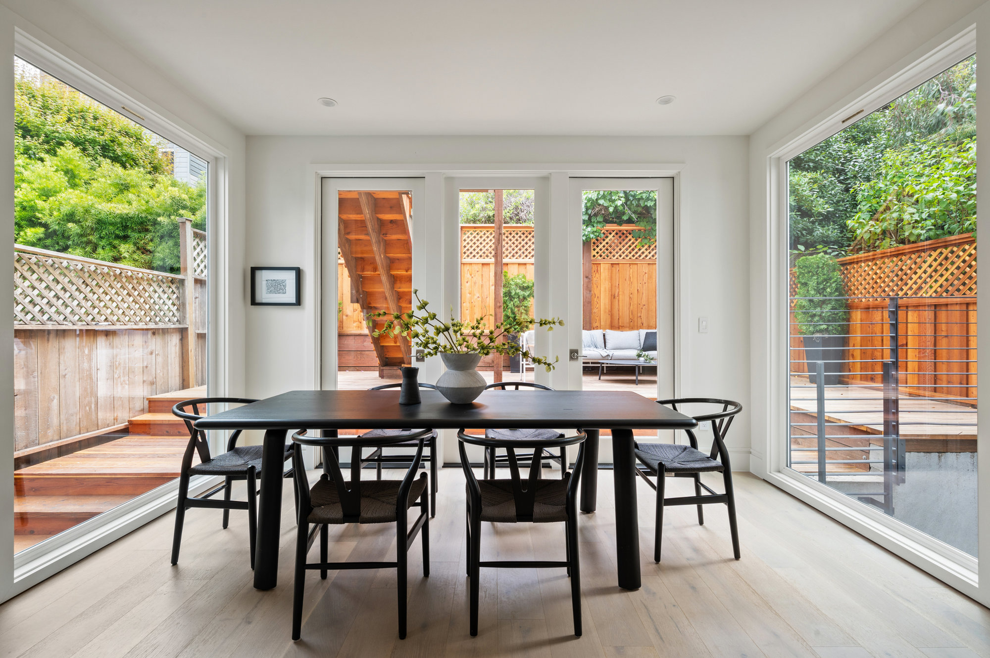 The dining room is engulfed by floor to ceiling windows and has french doors that open up to outdoor space.