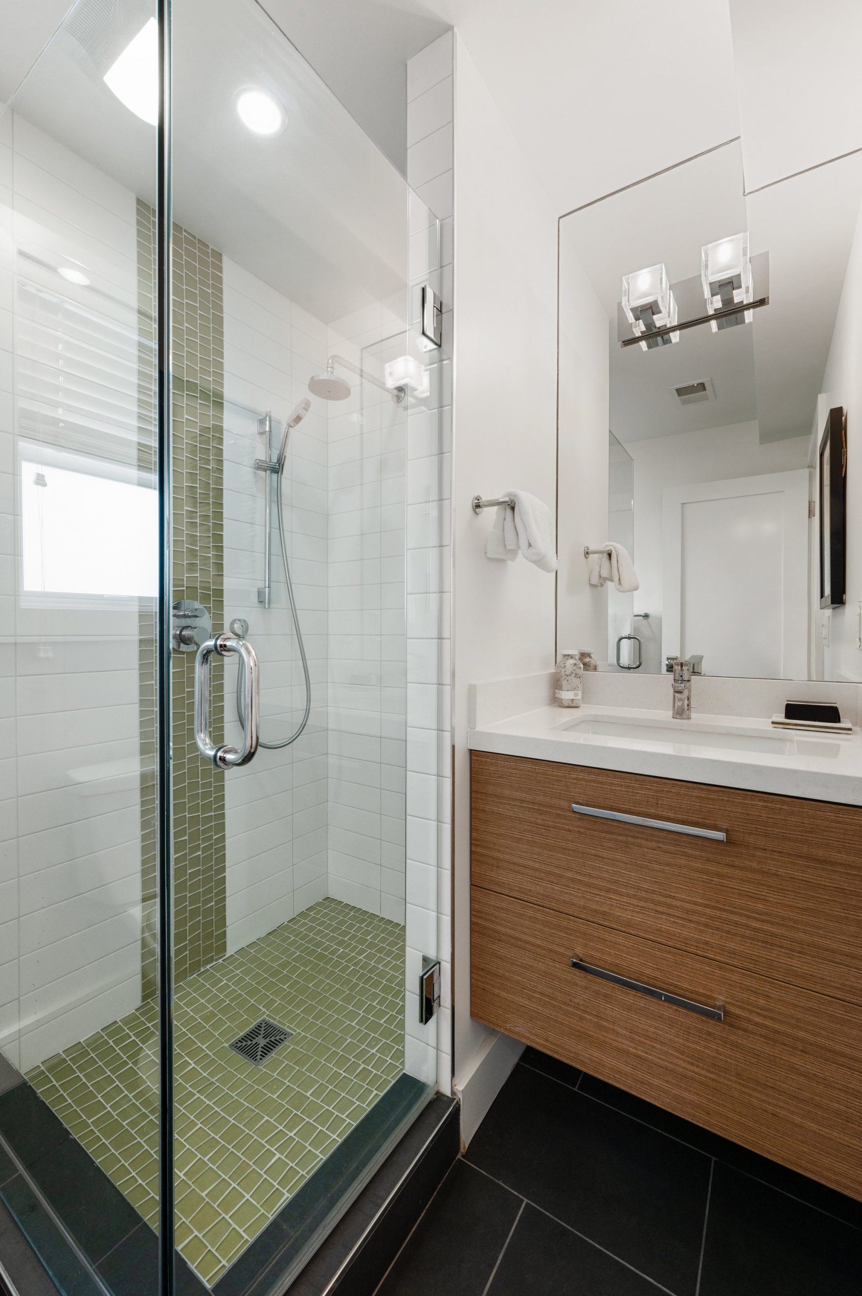 View of a bathroom with glass shower and vanity
