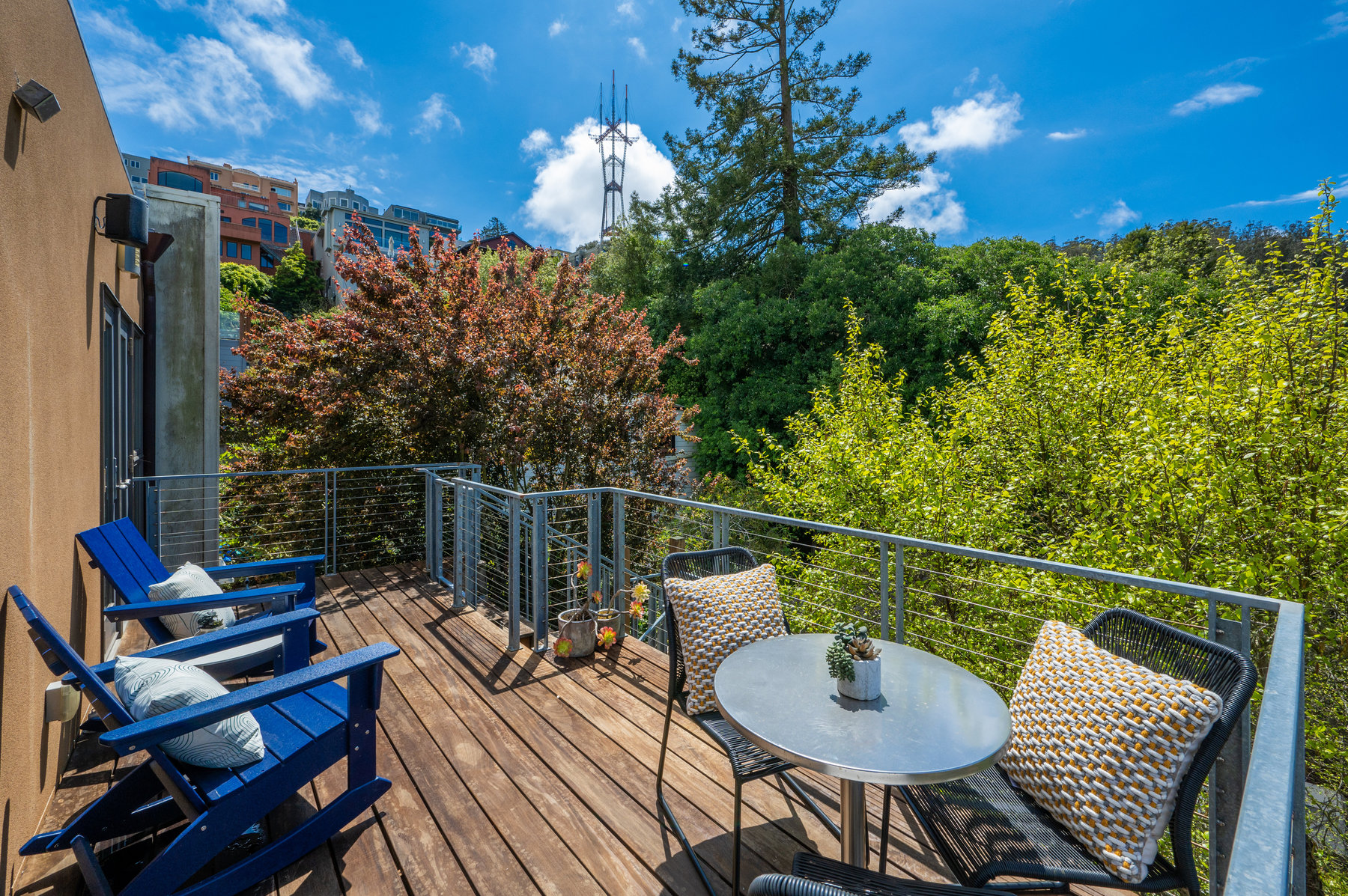 Deck off both bedrooms has two adirondack chairs and small table with two chairs.