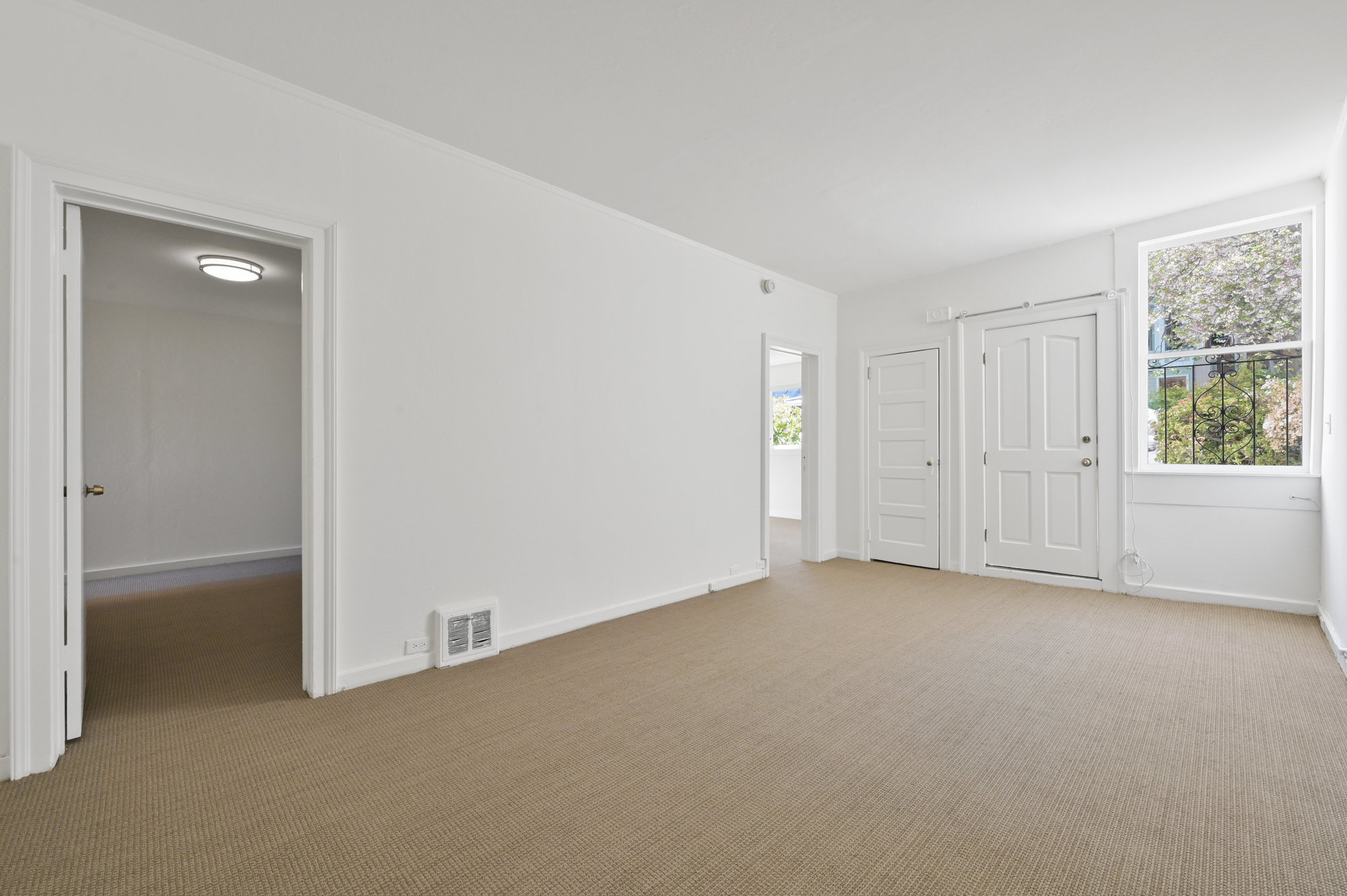 046060-1 View of a long room with large window and carpeting