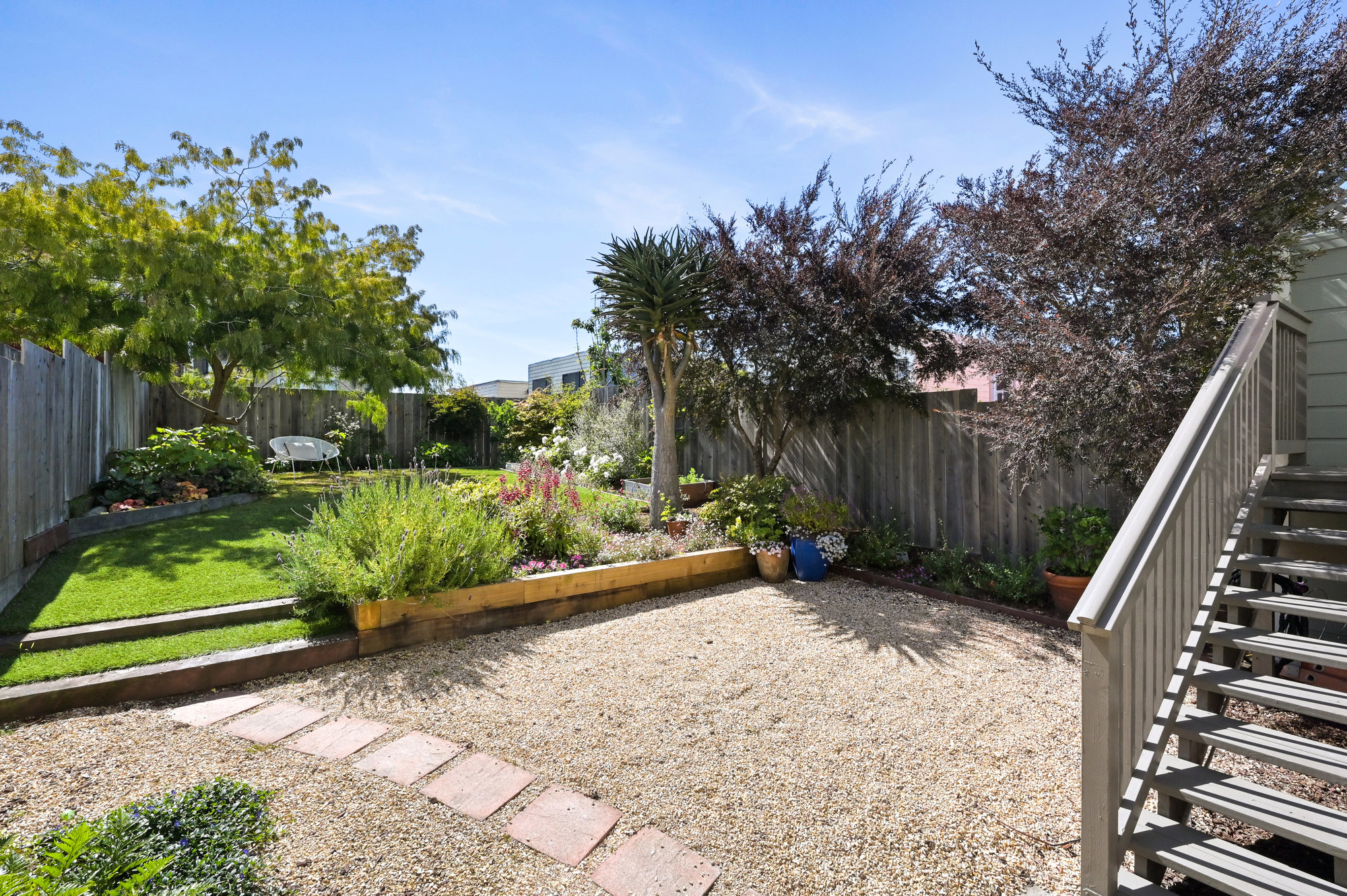 View of the large rear yard at 719 18th Avenue, showing various plants and trees