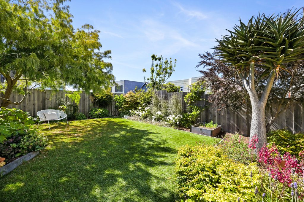 View of the raised flower and vegetable beds surrounded by trees