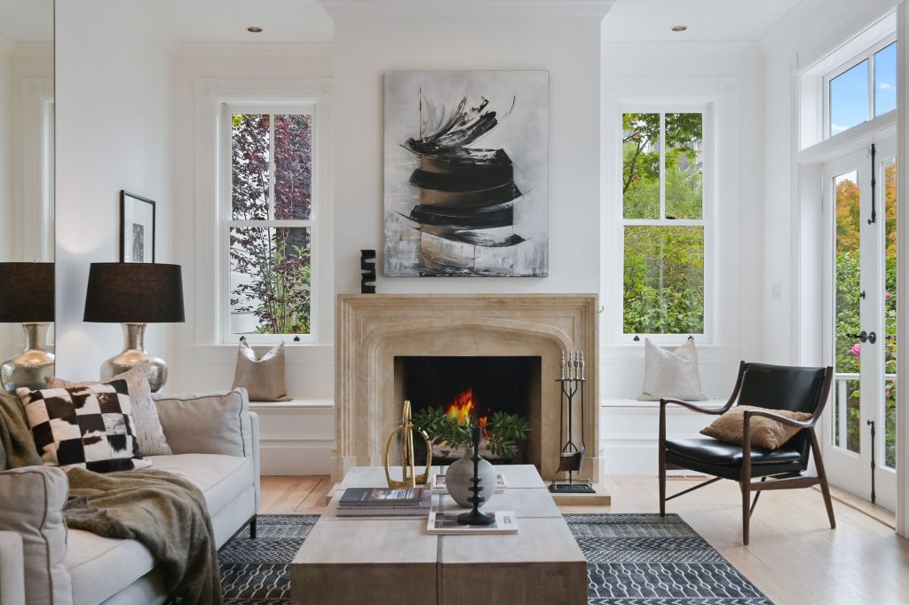 View of a living room with fireplace and large windows