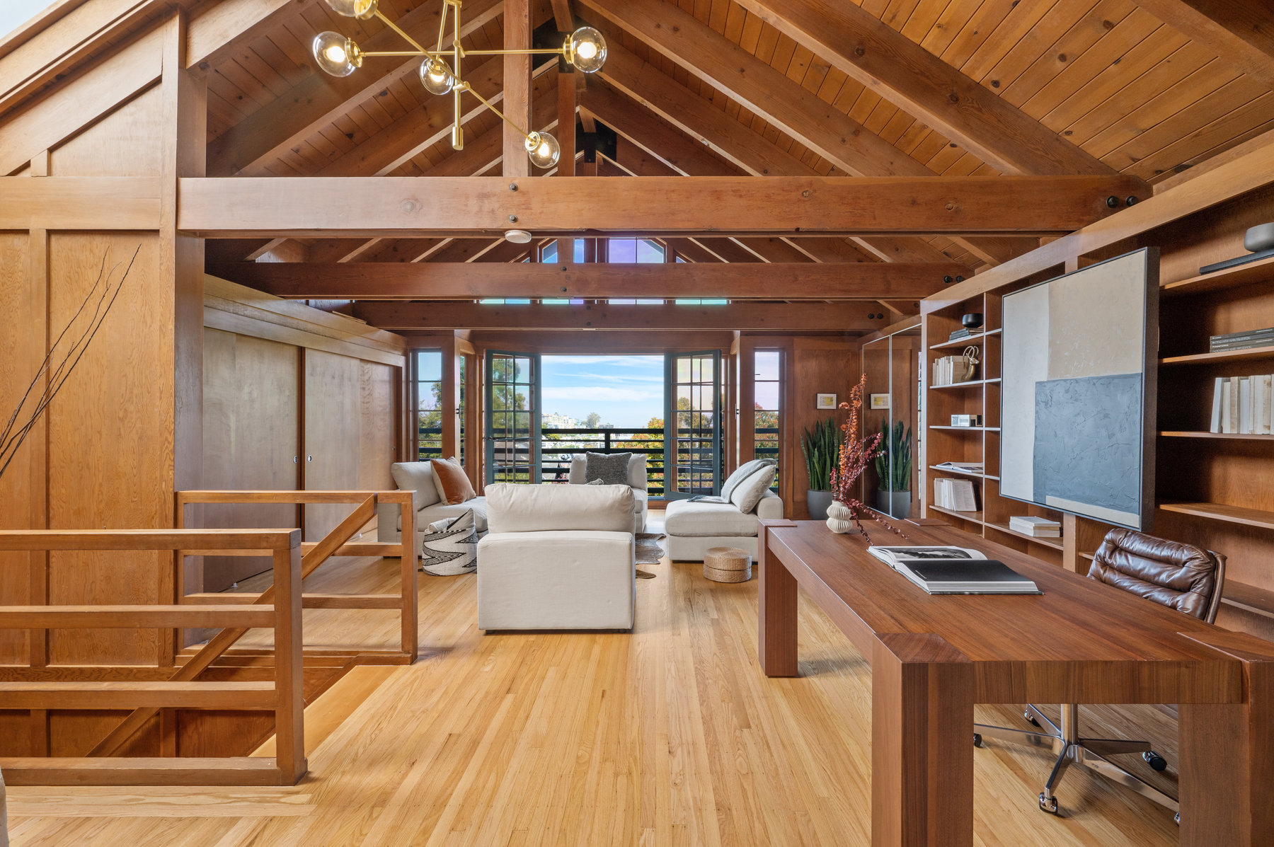 View of the upper level suite with a large living area and wood floors, walls, and ceiling