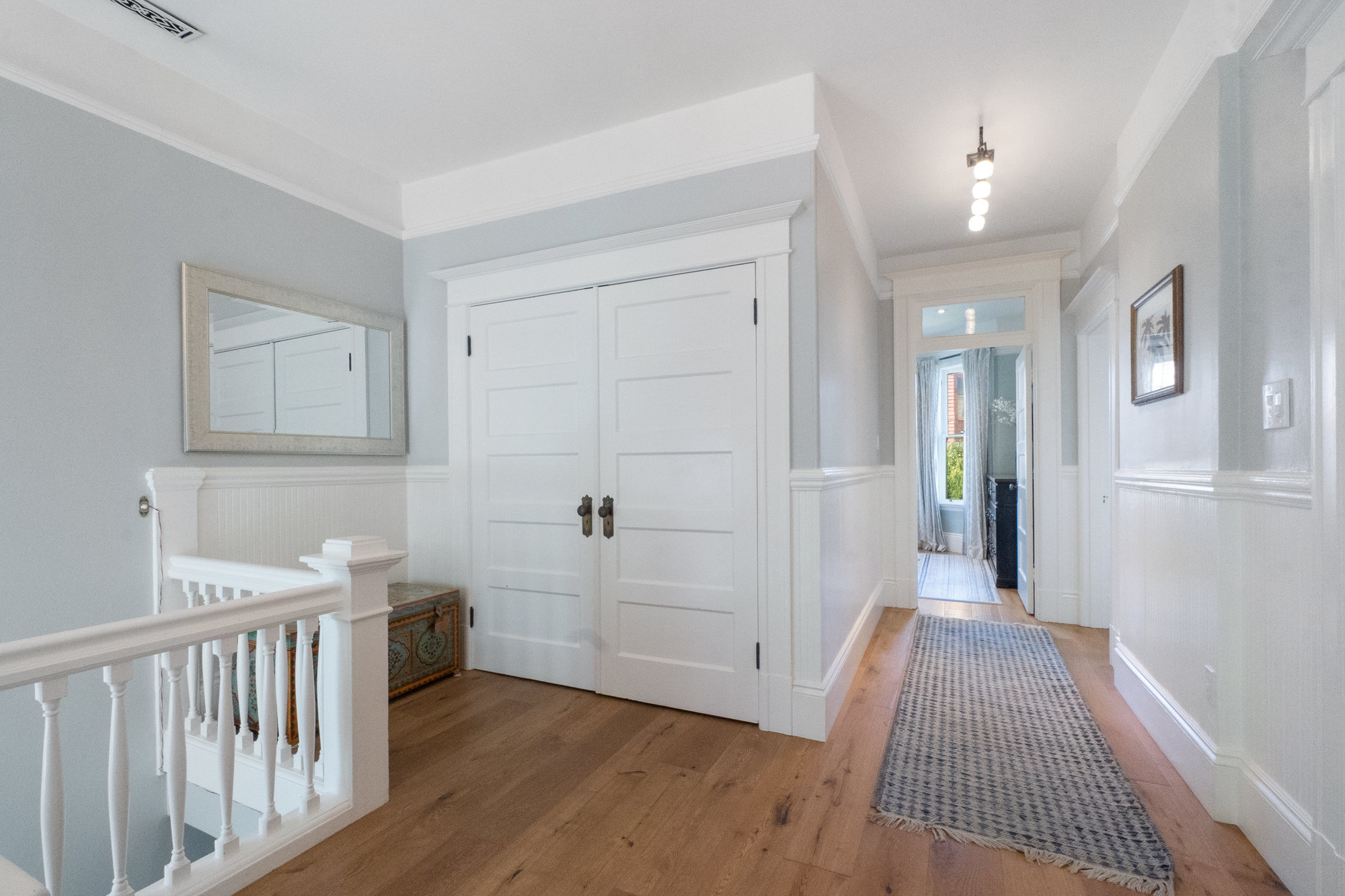 049058 View of a large double closet in the hall and wainscoting throughout