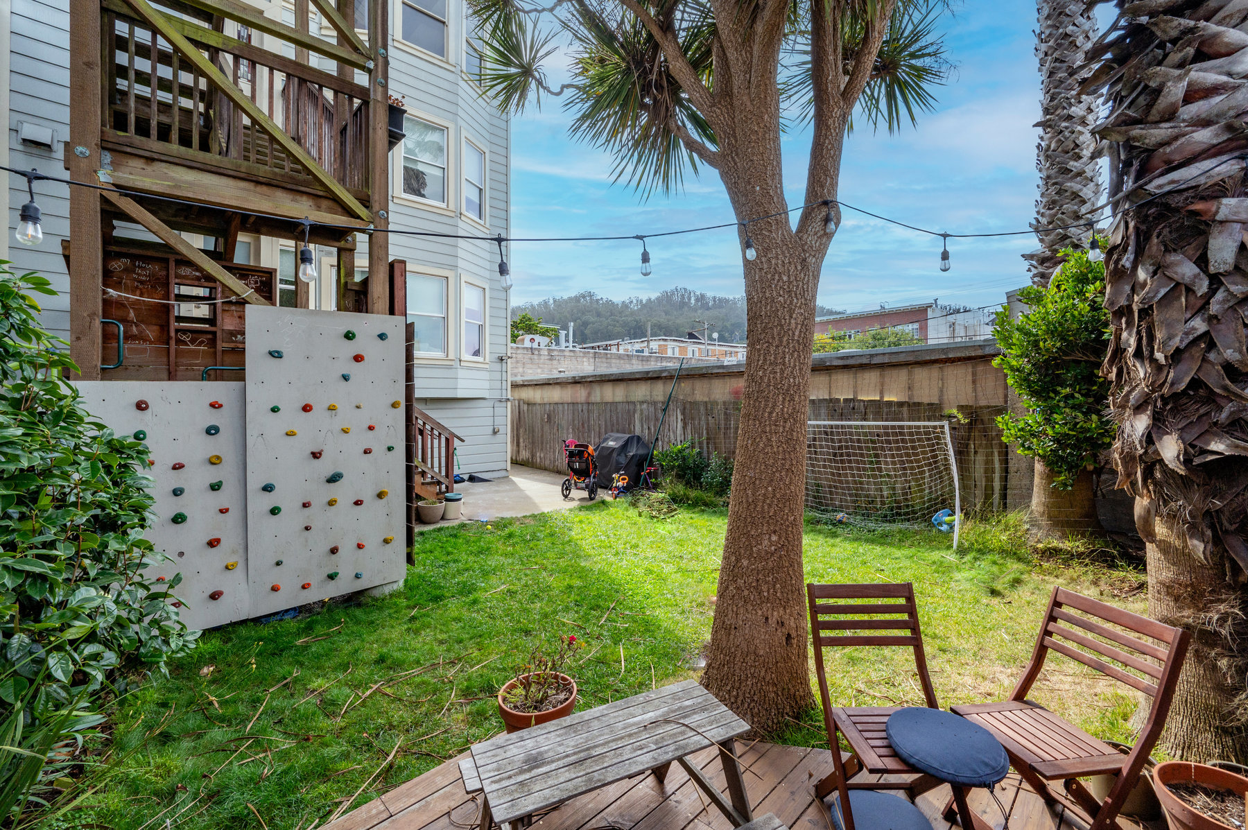 Photo of shared yard.  There is grass and a sitting area on small deck.