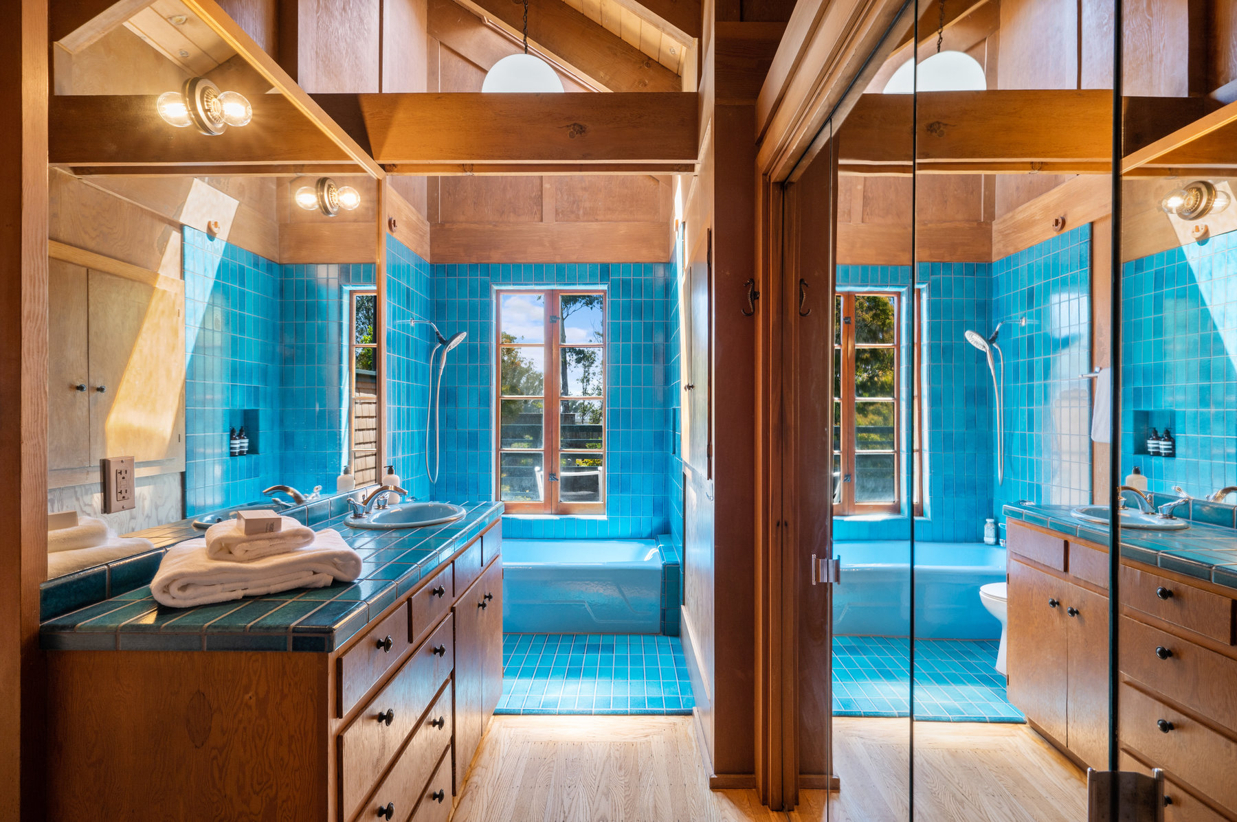 Upper level bathroom that has stunning teal blue Heath Tile on counter top and shower. Large window over tub that looks out to back yard.