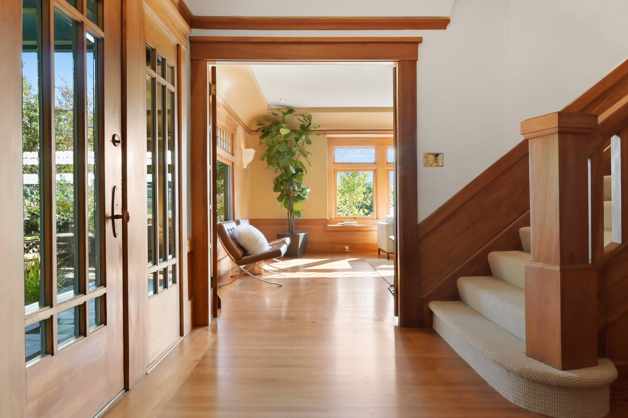 View of the hall showing light cascading in a window across beautiful wood floors