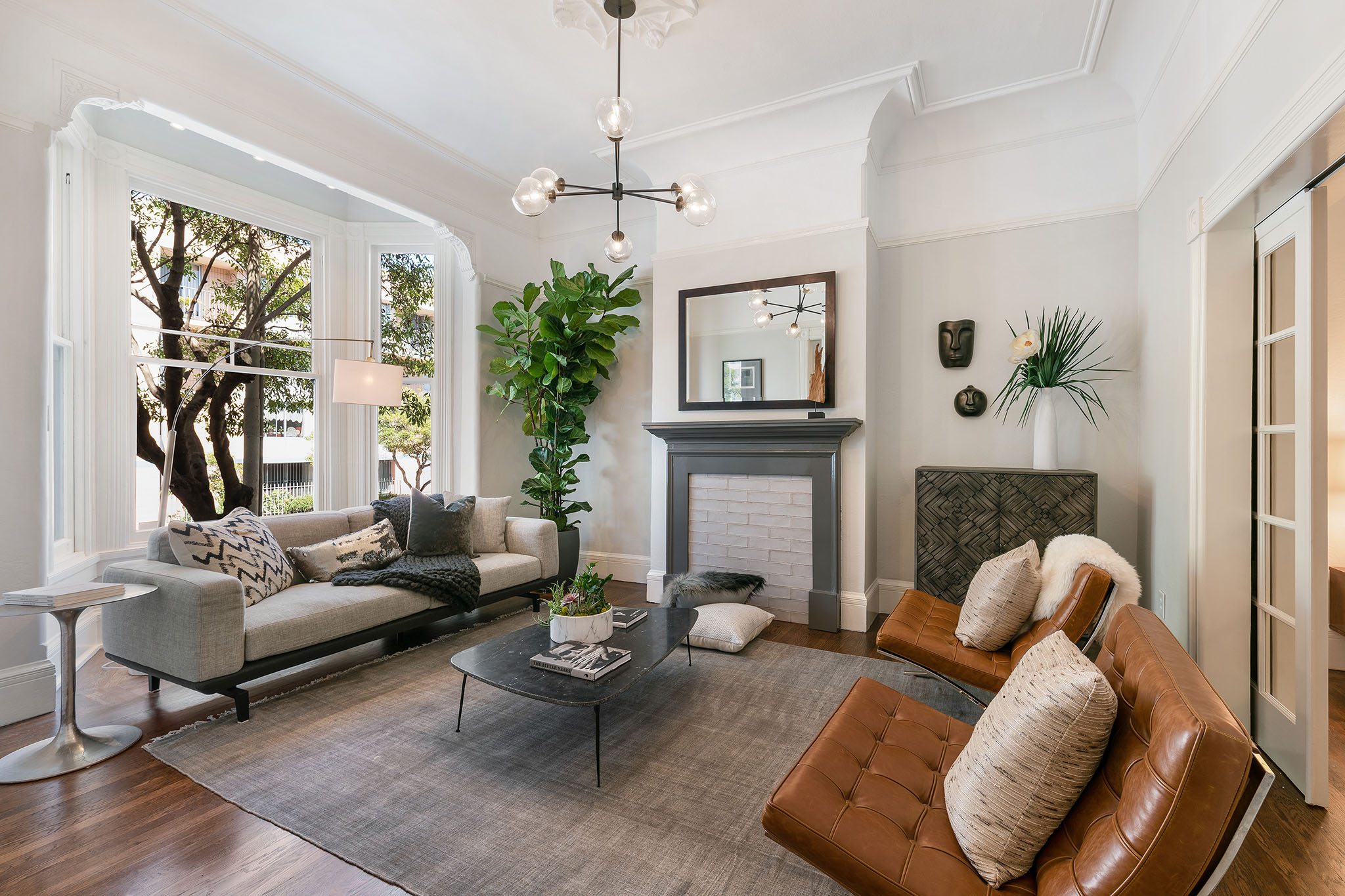 06 View of the living room, featuring a large arched window and crown moulding