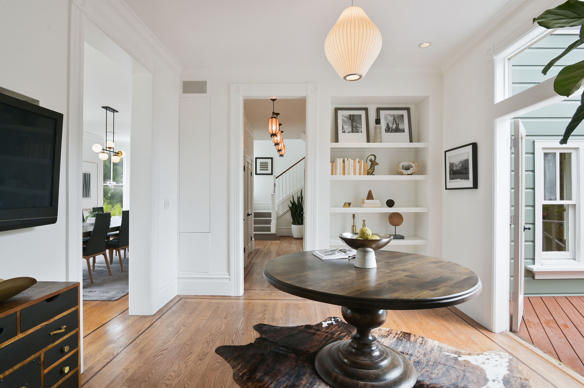 View of a hall with wood floors and white built-in cabinets
