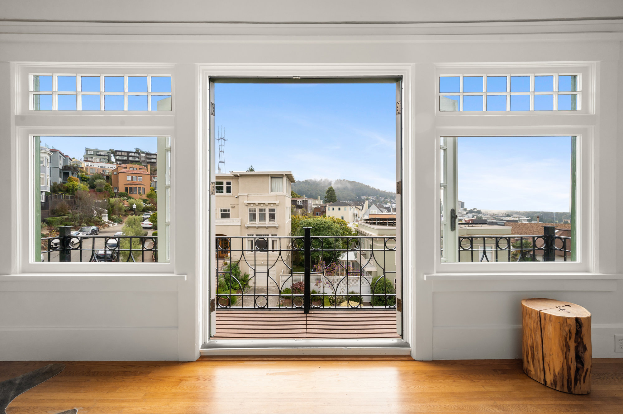 Open French doors showing the balcony adjacent to the primary bedroom