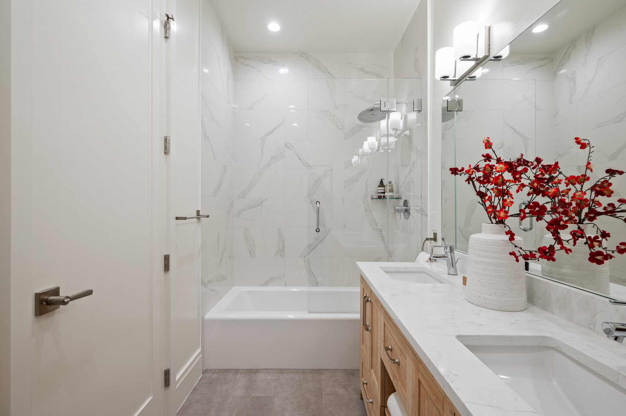 Primary bathroom. White walls, bath tiles and double vanity.