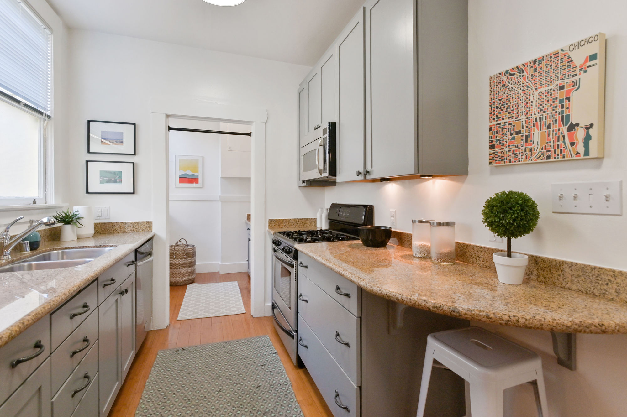 Galley kitchen with wood floors and grey cabinets
