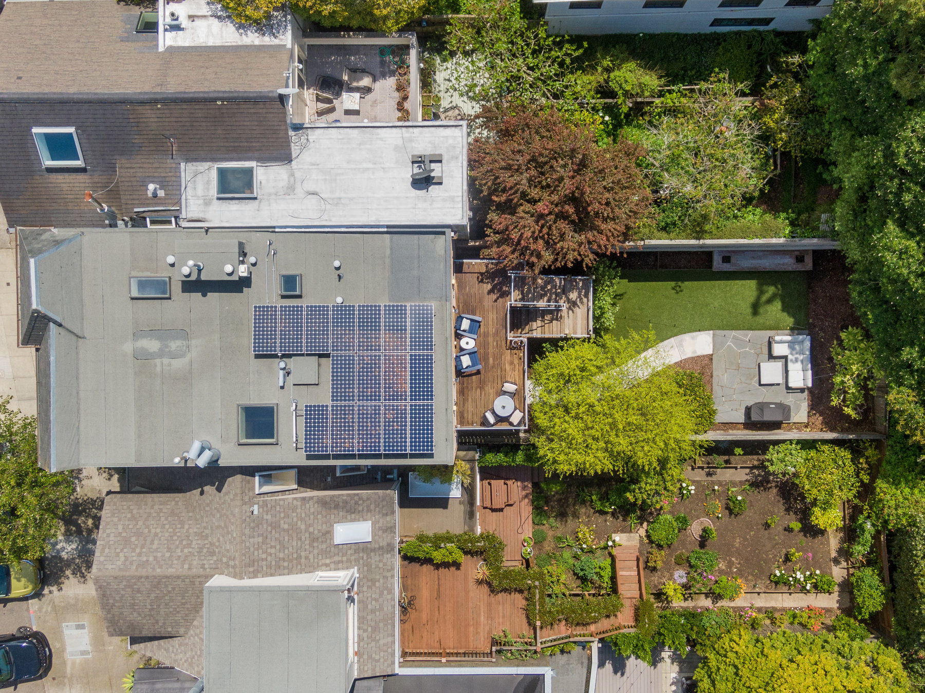 Aerial from above 1521 Cole. You see the roof, solar panels, and full shot of yard.