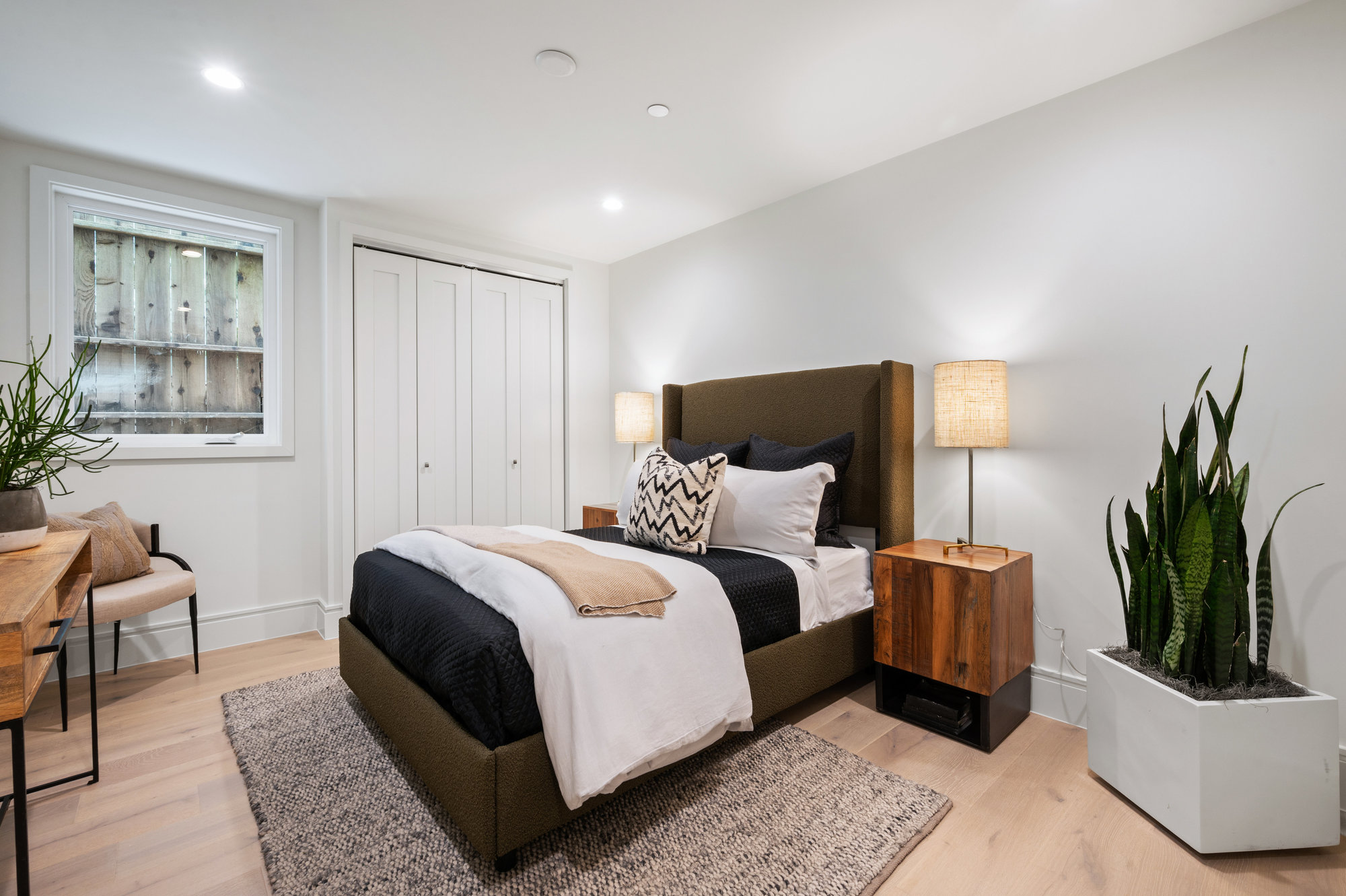 Guest bedroom on lower level has queen bed with two nightstands.  There also is window.