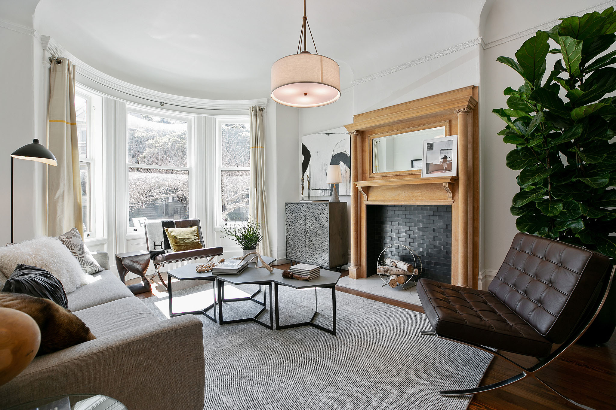 07 View of the living room, featuring a wood mantle and large bay windows