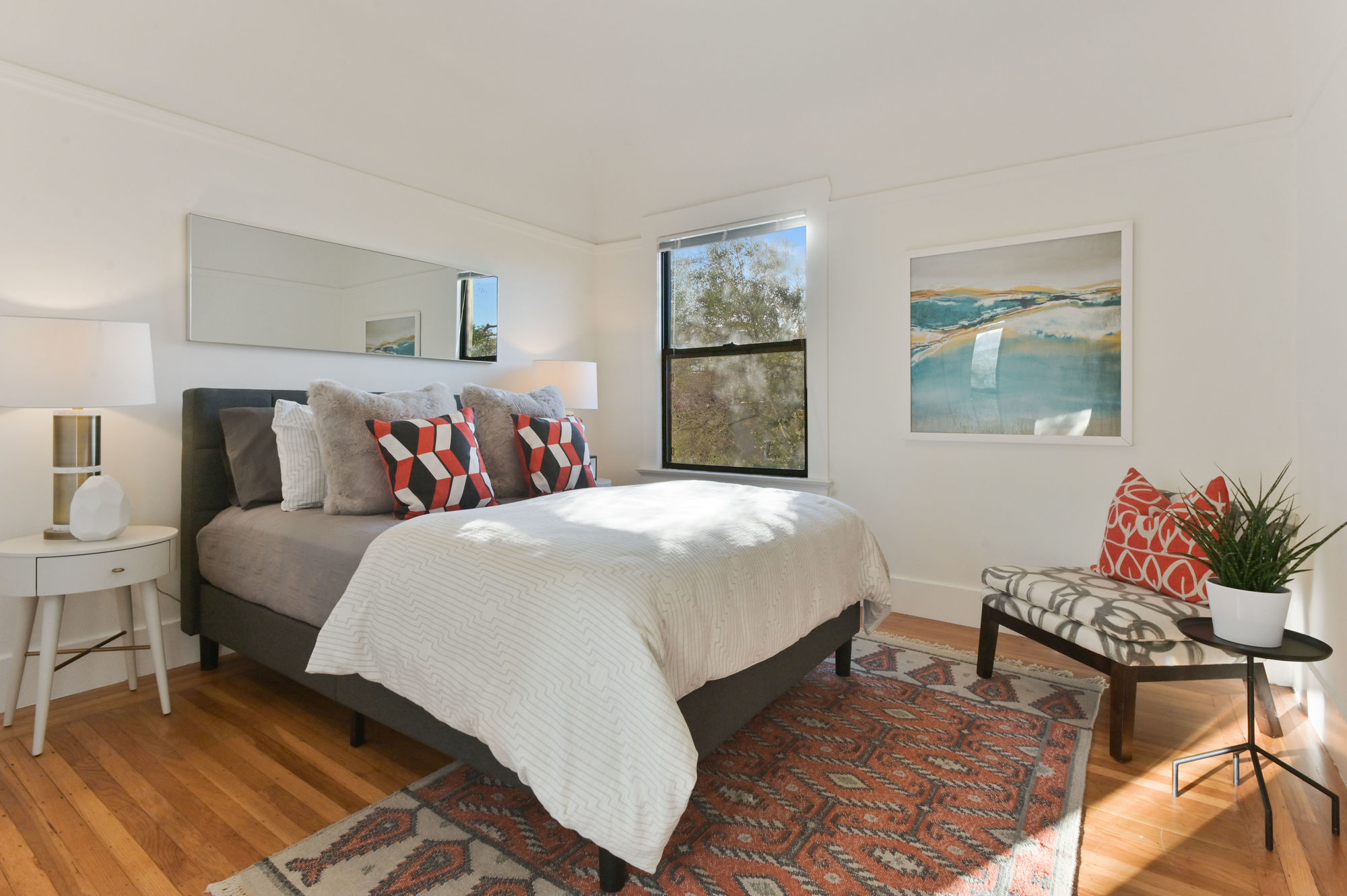 View of another bedroom with window and wood floors