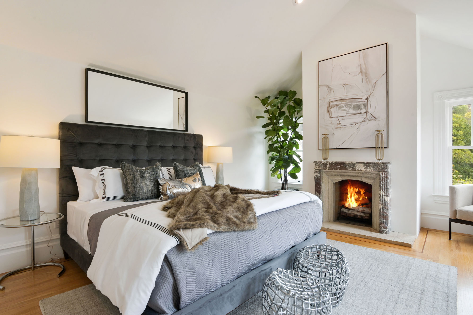 Primary bedroom with a fireplace and wood floors