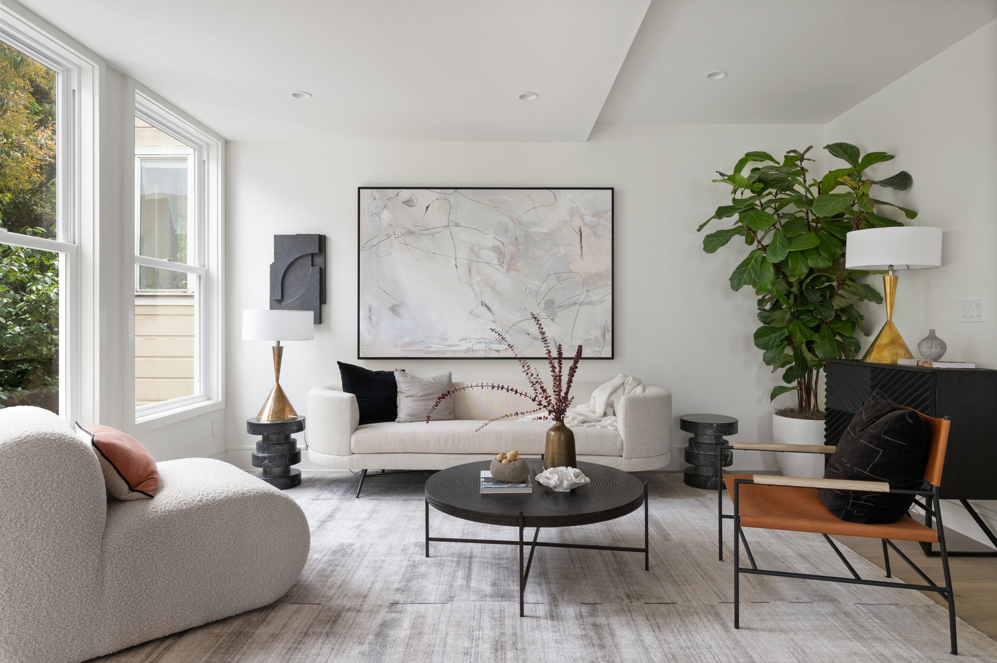 Looking at living room space. There are large windows to the left that let in lots of natural light.