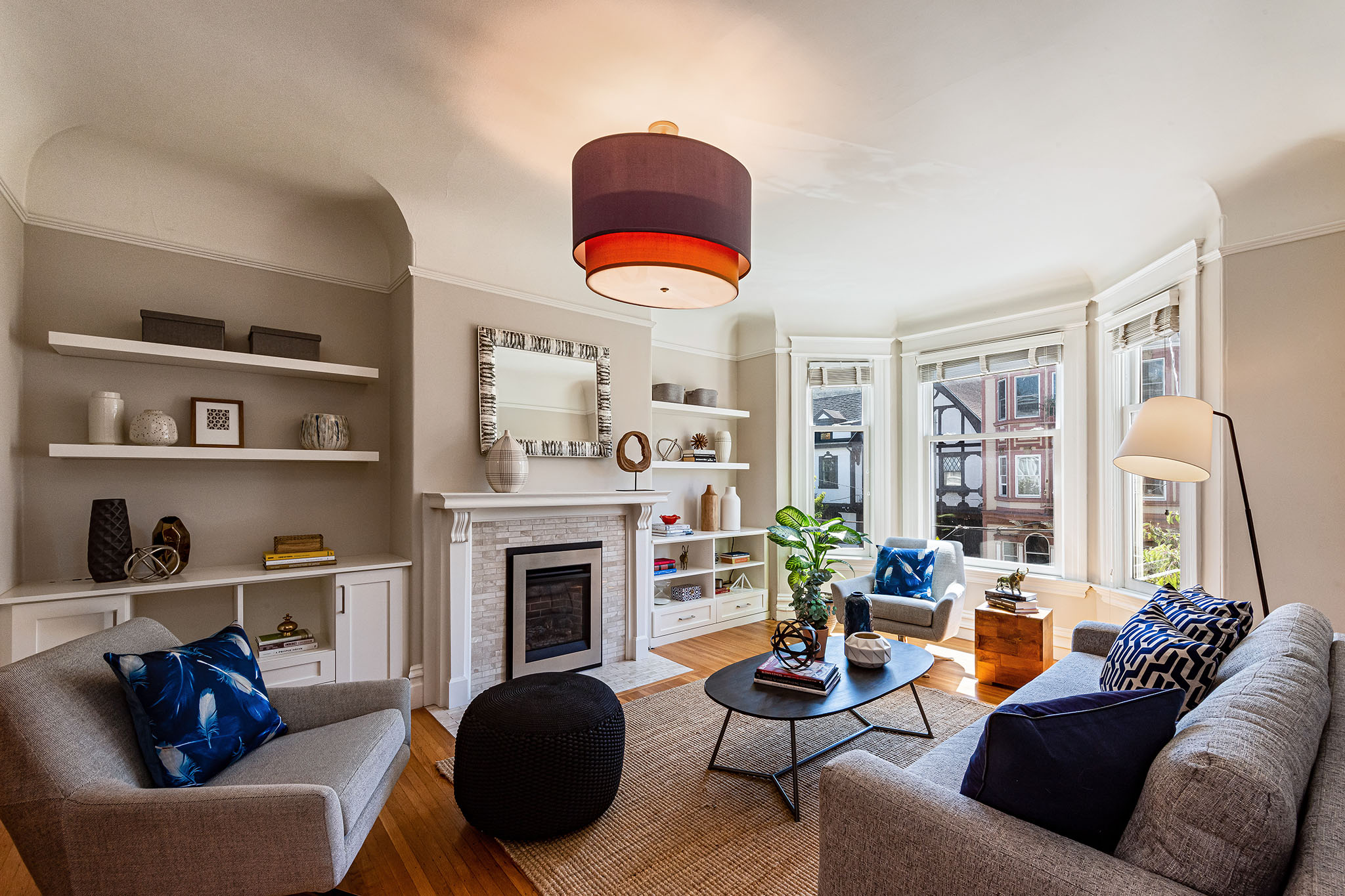 View of the living room, showing a fireplace with white shelving on either side