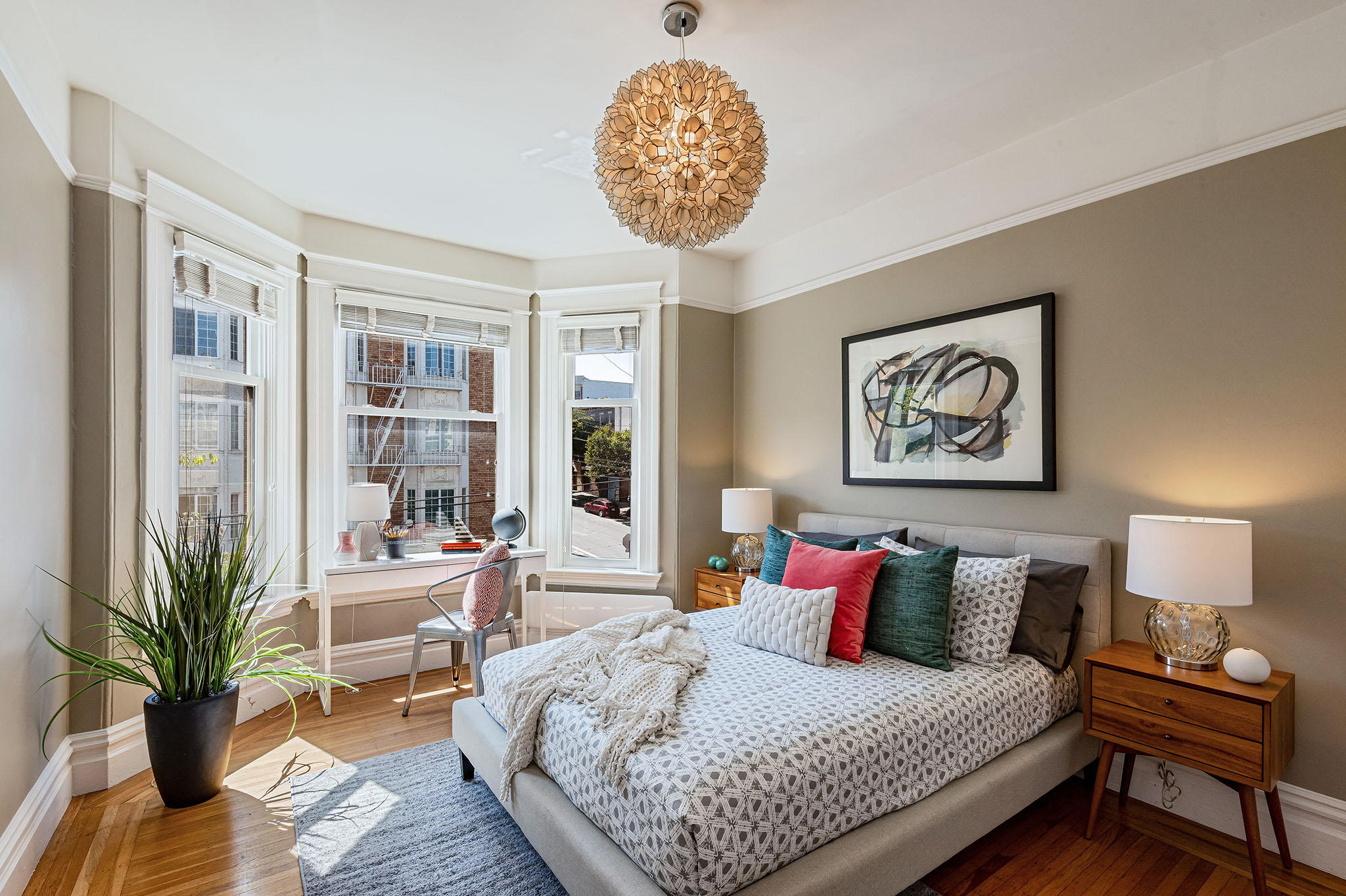 View of a second bedroom, showing large windows, modern light fixture , and wood floors