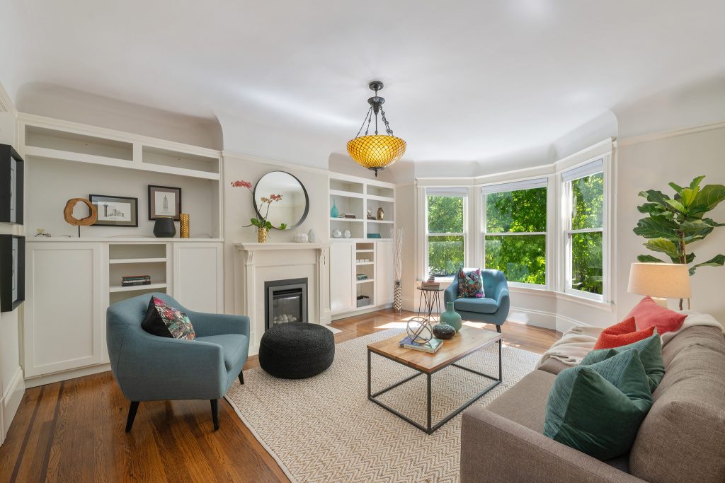 View of the living room at 1056 Cole Street, featuring a fireplace, built-in shelves and bay window