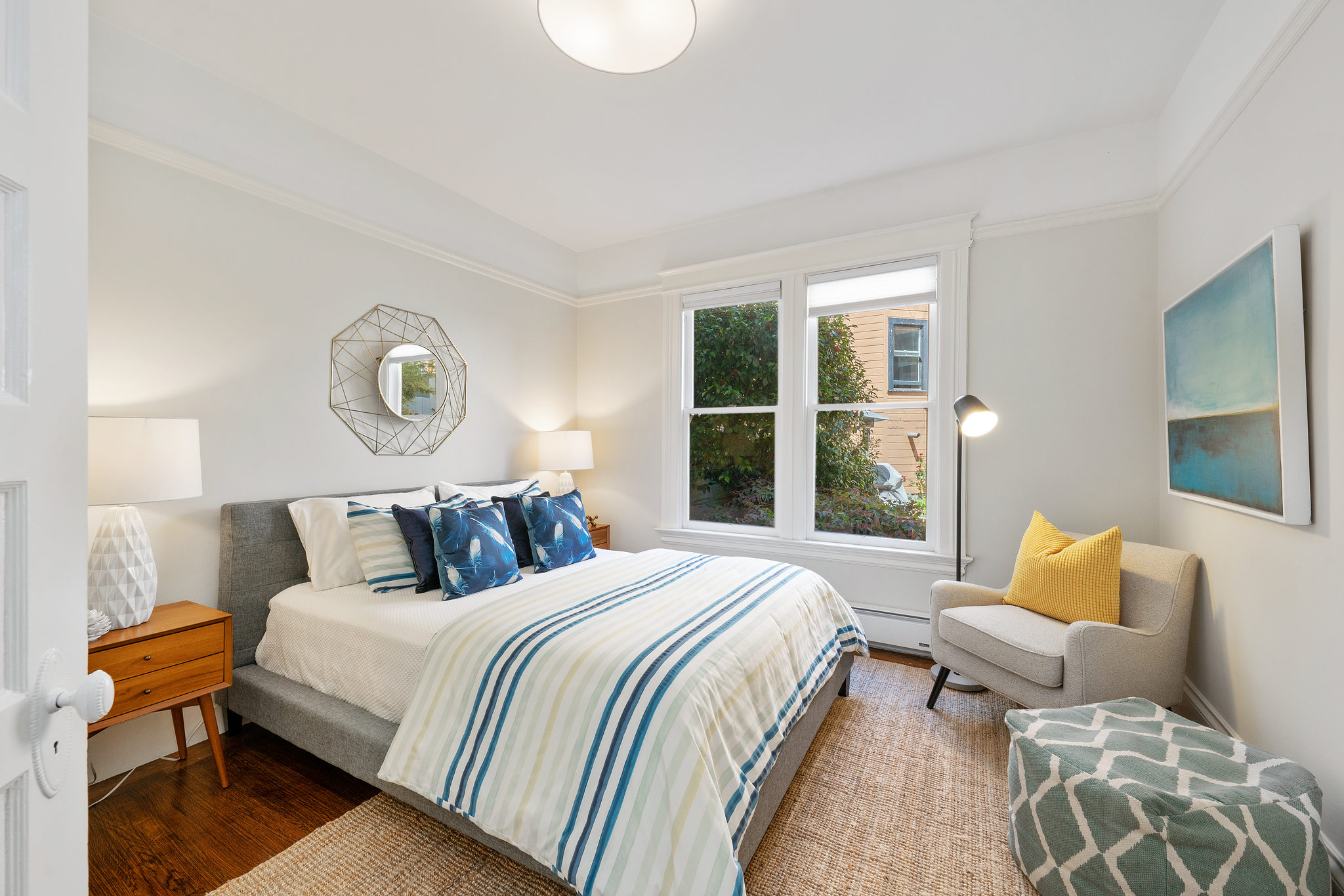 Bedroom with wood floor and two large windows