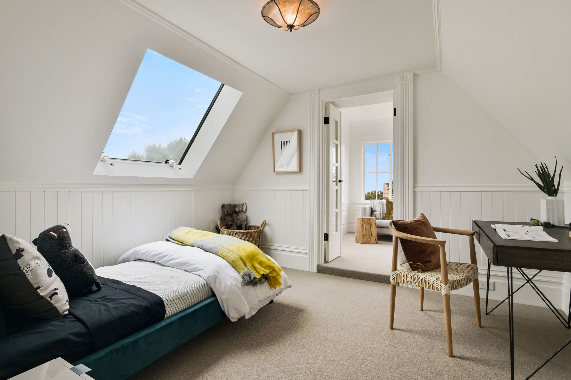Bedroom with slanted ceiling and a skylight over the bed