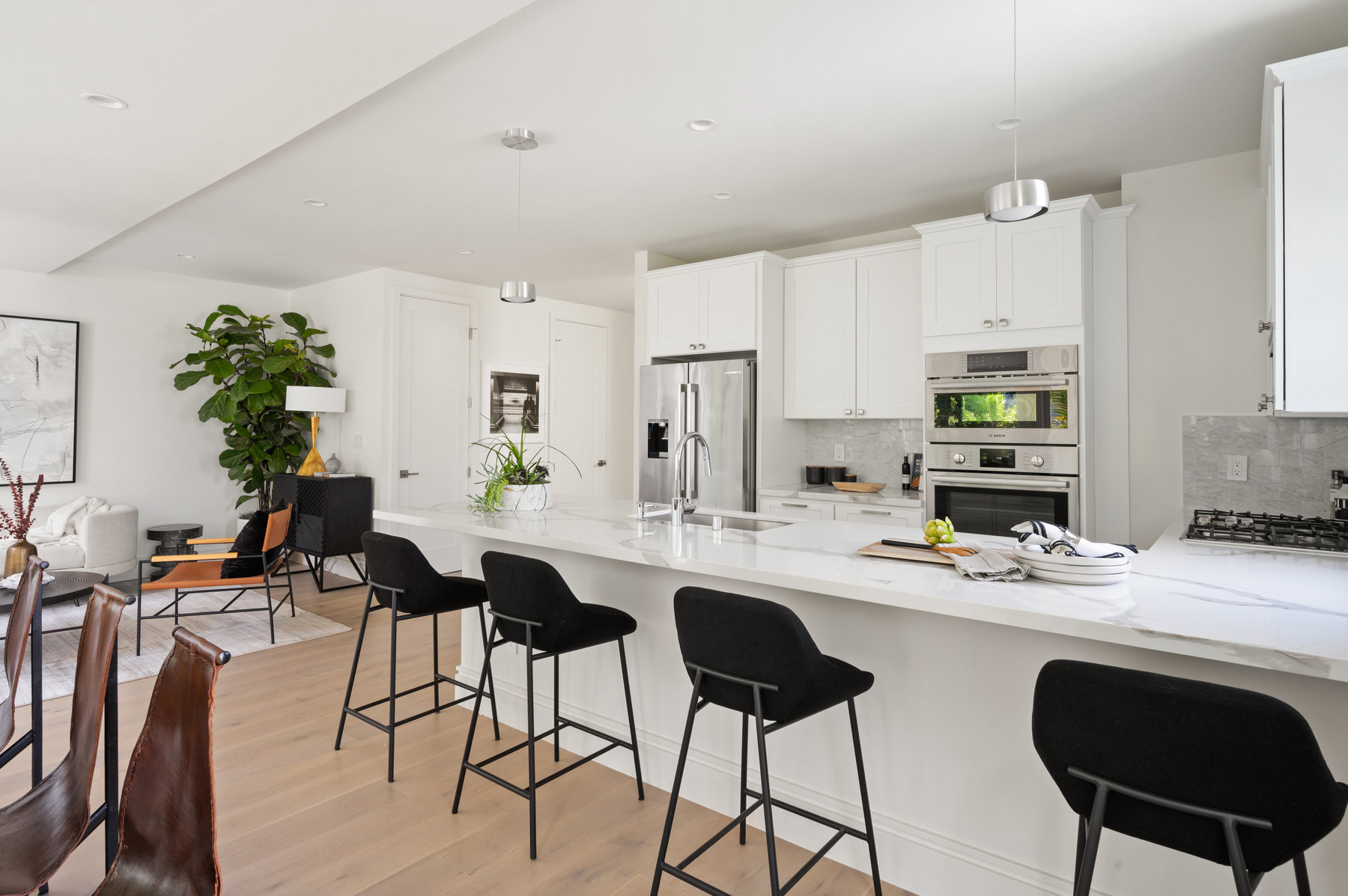 A large room with kitchen and island with counter seating