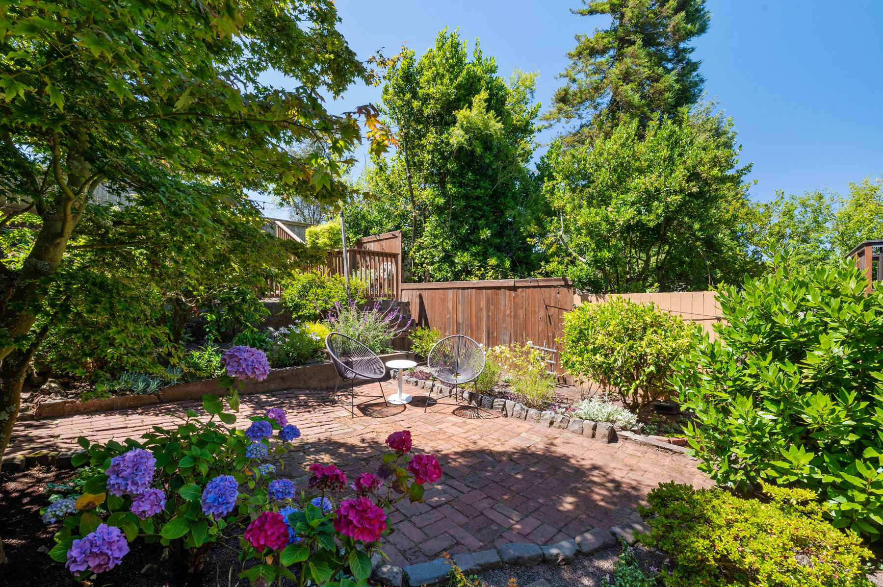 Back yard is fences in and has small sitting area in the middle.