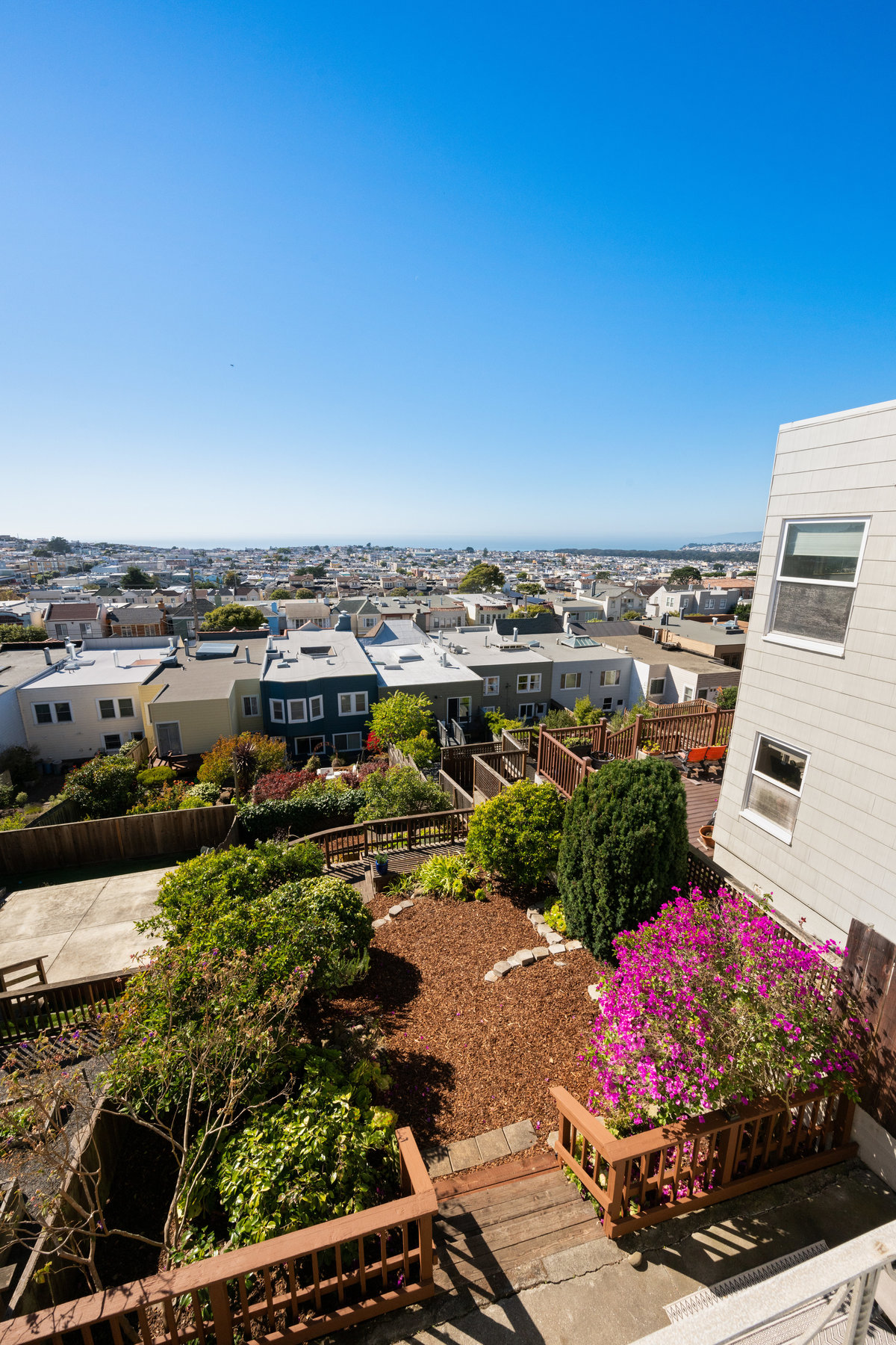 Looking over the beautifully landscaped yard from the back deck. You can also see the ocean.