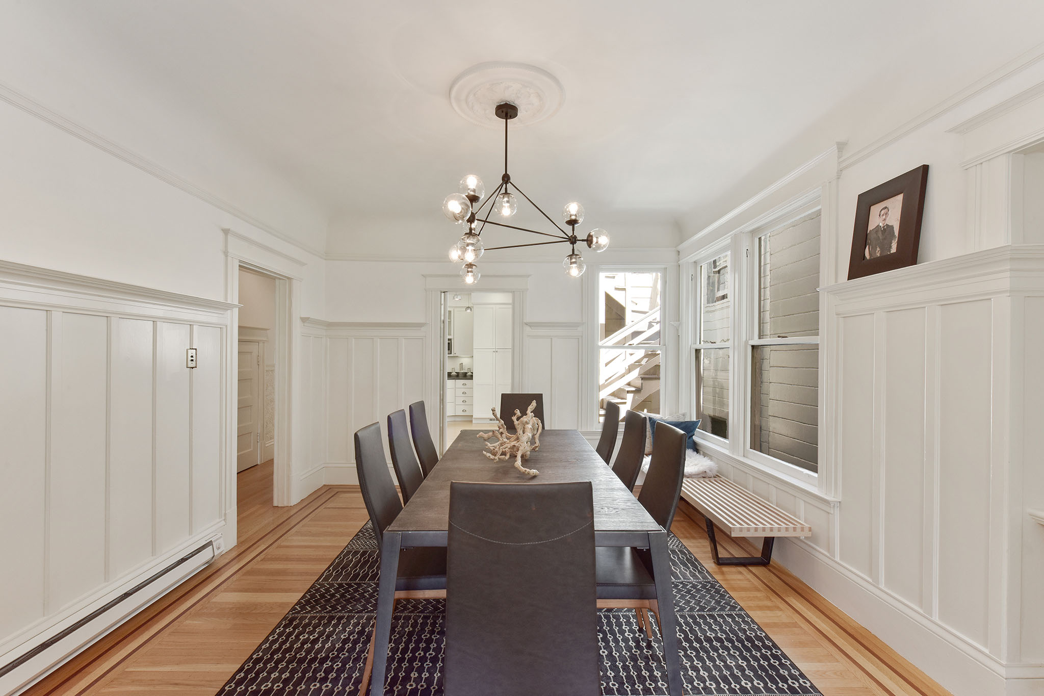 View of the formal dining room with white wood wainscoting