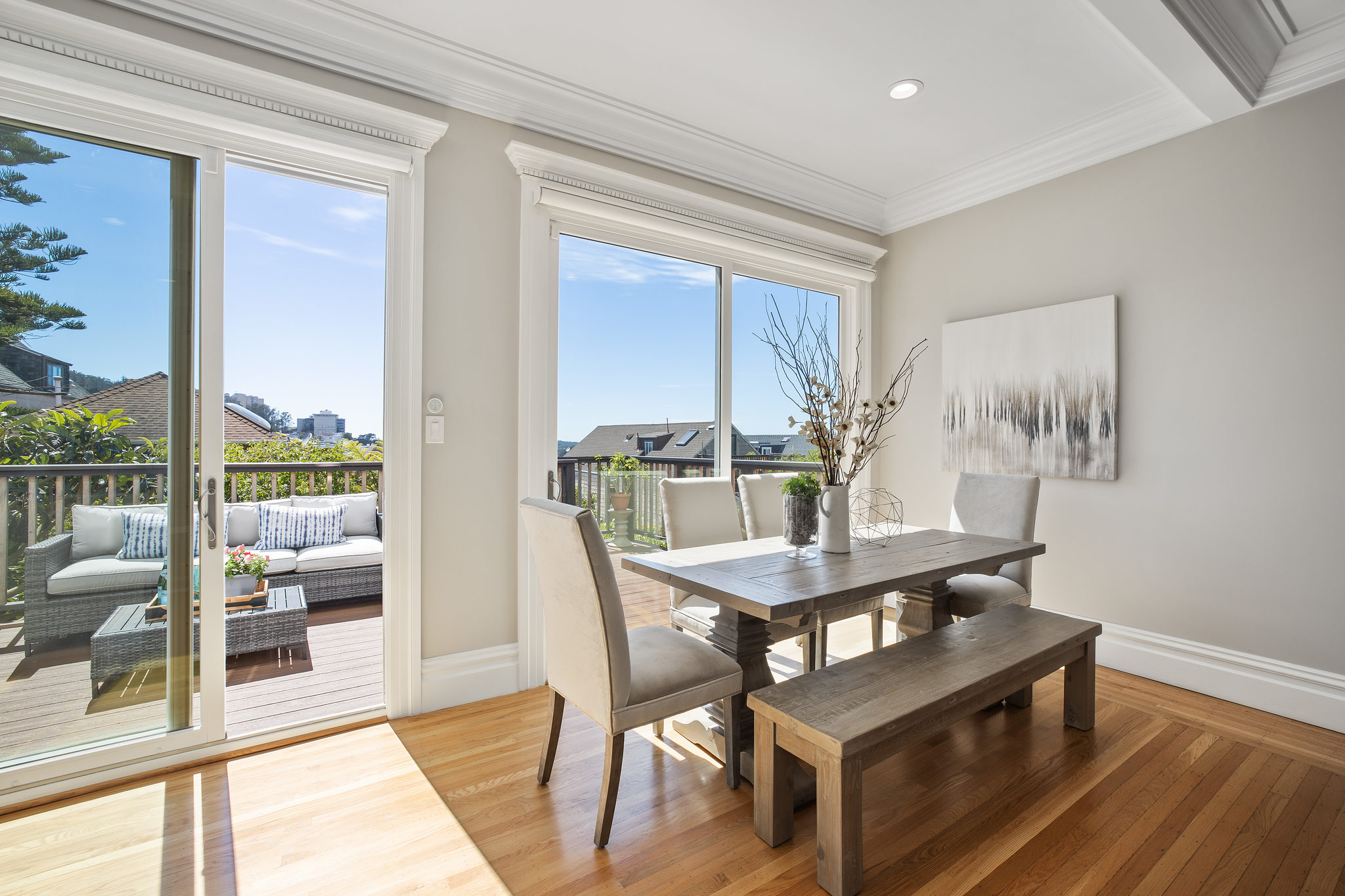 Eat-in kitchen space with large windows and doors, featuring a partial view of the adjoining deck