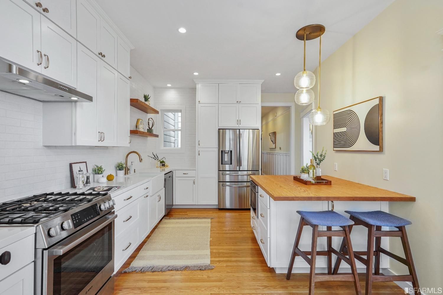 Kitchen featuring white cabinetry, lux stove, and modern lighting