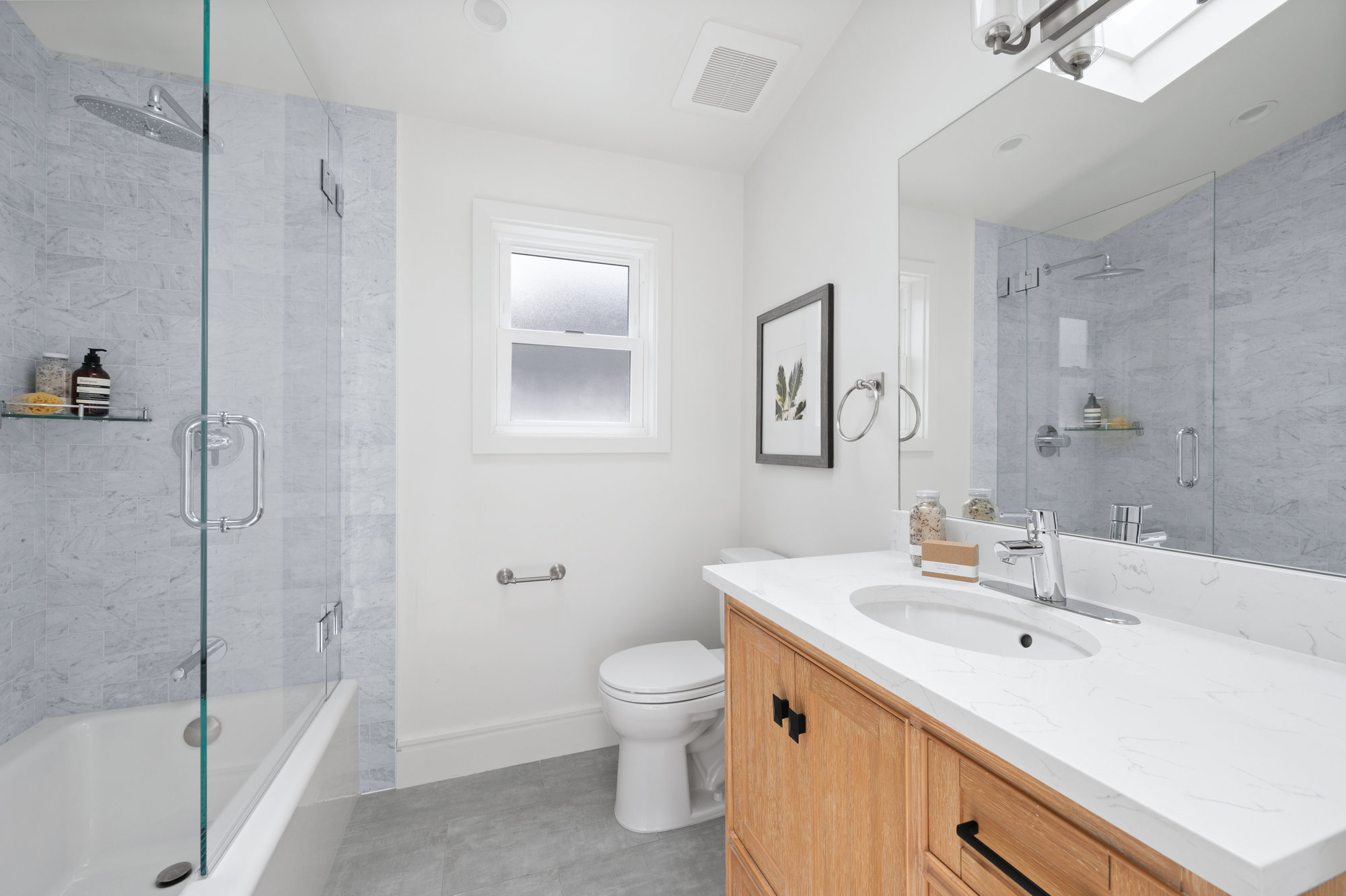Another photo of the bathroom showing vanity and tub/shower combo.