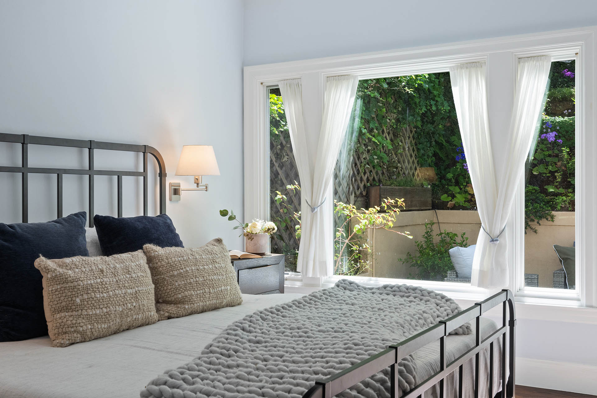 1525willard-bedroom-2-1 Looking over the bed through window at the lush greenery in the backyard.