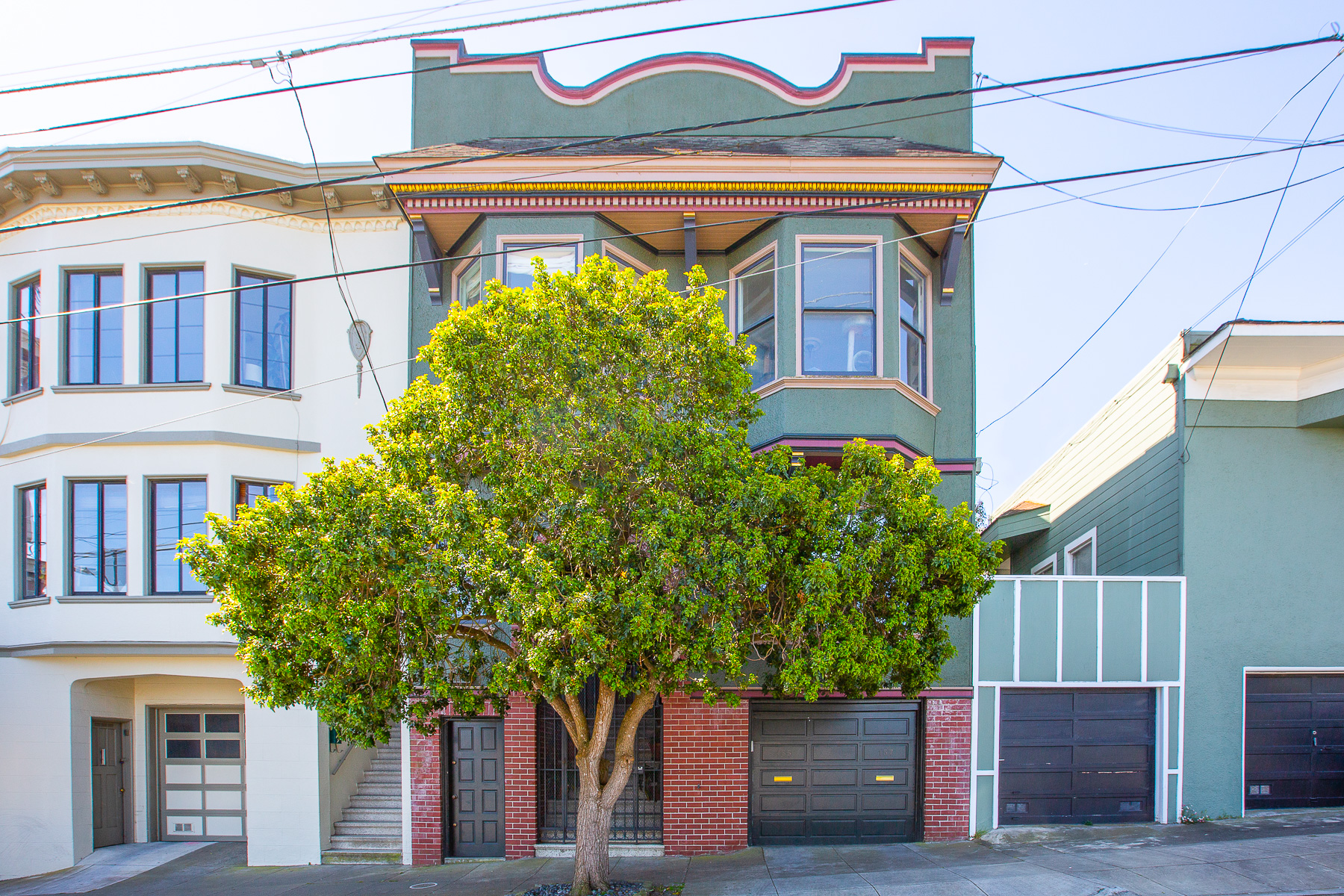 View of the front exterior of 157 Alma Street, featuring a green facade
