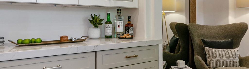 A green chair positioned near cabinets and a lamp